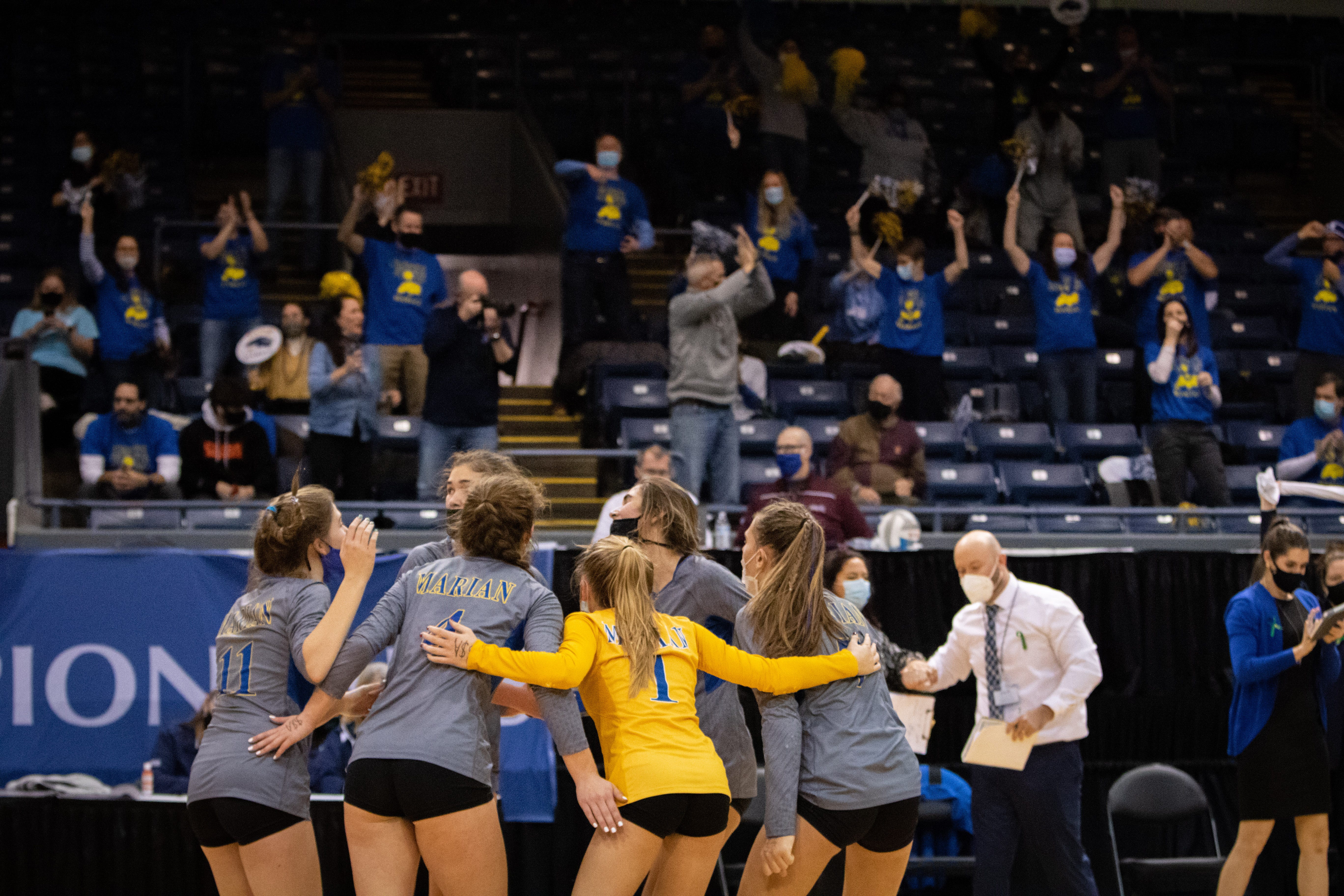 Marian players celebrate a point won while fans cheer as Bloomfield Hills Marian defeats Lowell for the Division 1 volleyball final.