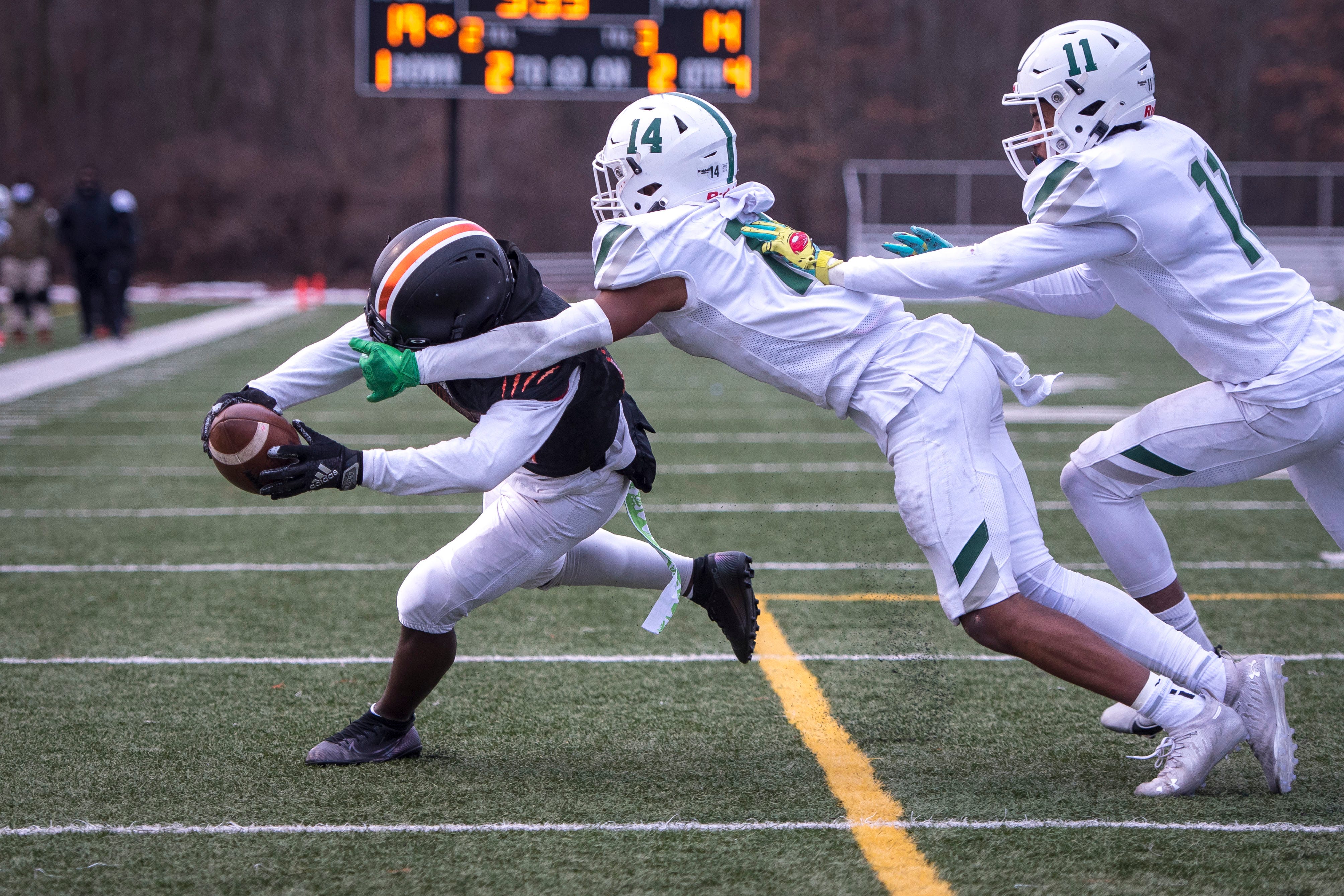 Belleville freshman wide receiver Kevin Simes (9) scores a touchdown against West Bloomfield senior defensive back Grant Lenton (14) and senior free safety Gavin Hardeman (11) during the fourth quarter.