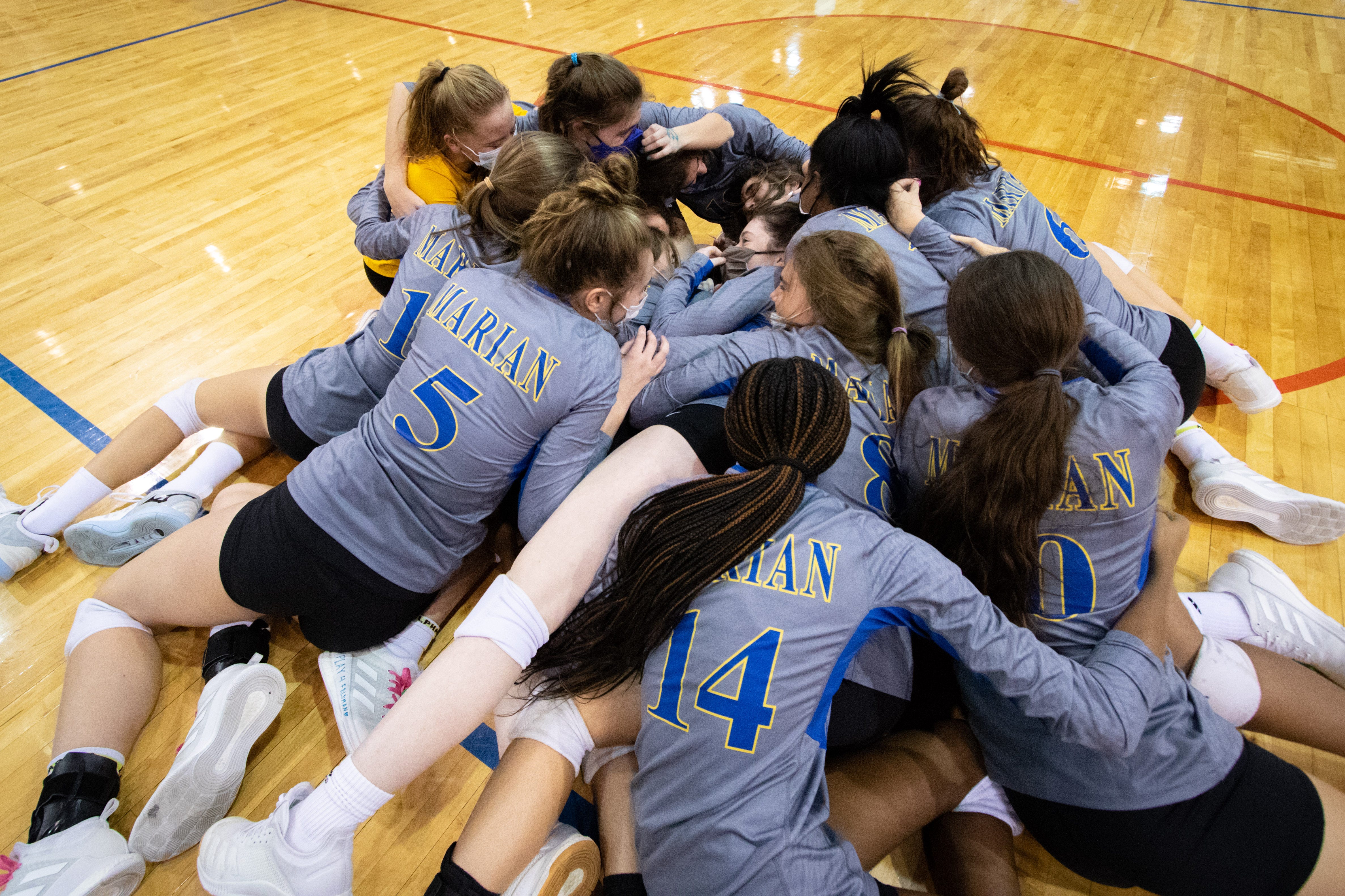 Birmingham Marian celebrates together after defeating Lowell for the Div. 1 volleyball title.