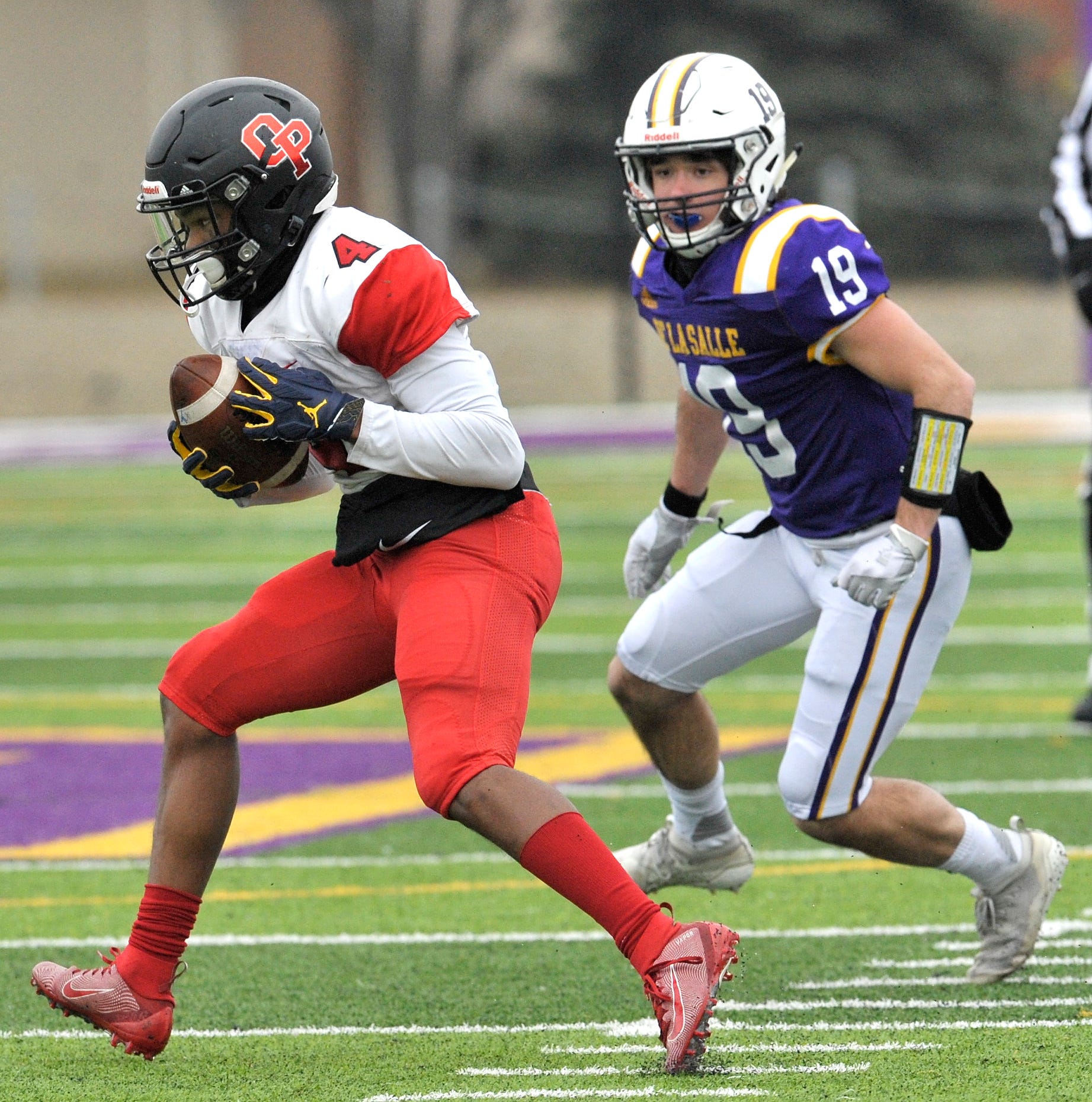 Oak Park's Amari Harris (4) receives the ball that is called back due to a false start as De La Salle's JC Ford (19) closes in to make the tackle in the first quarter.