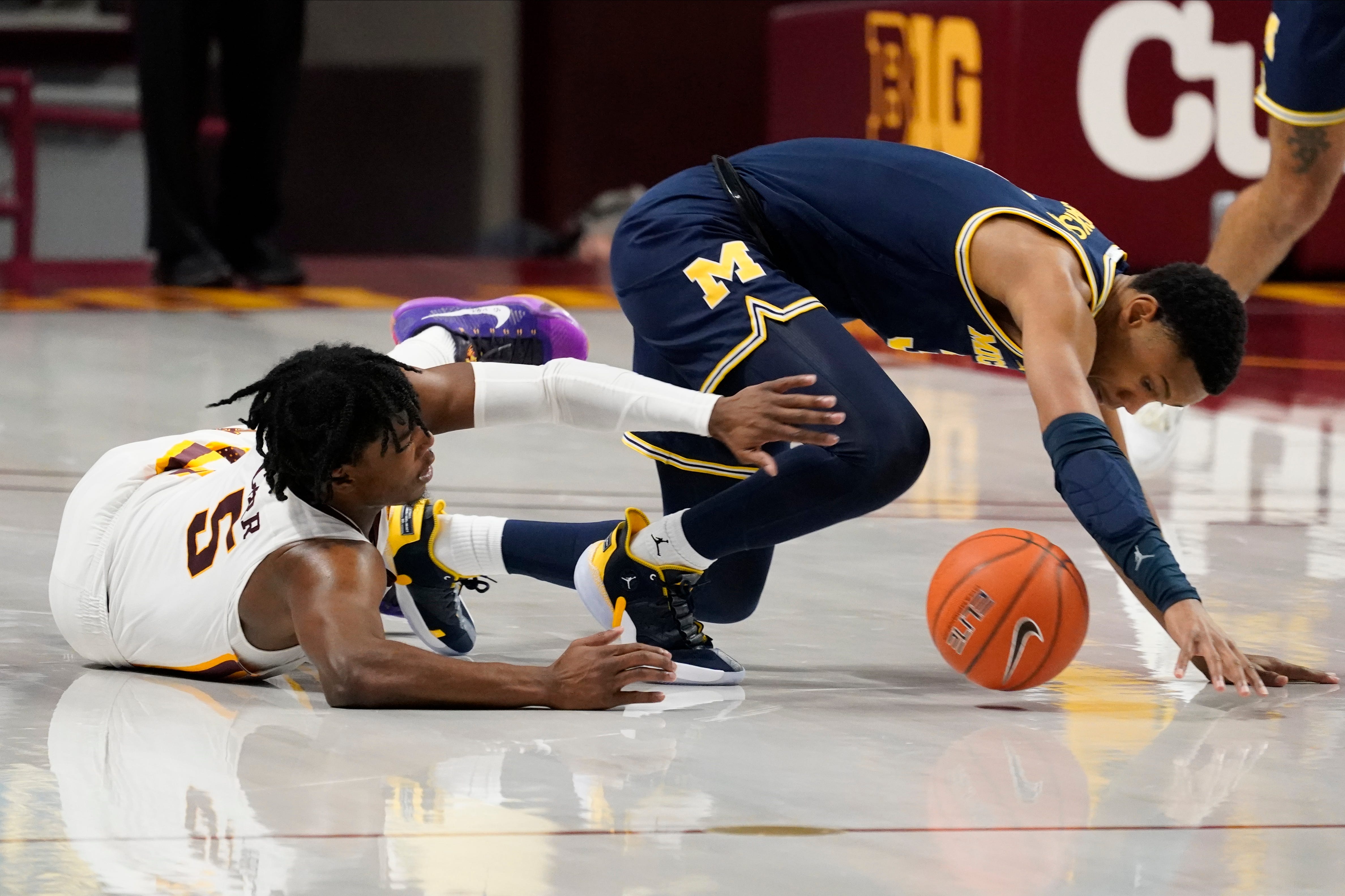 Minnesota's Marcus Carr (5) and Michigan's Zeb Jackson (3) battle for the ball after a collision in the second half.