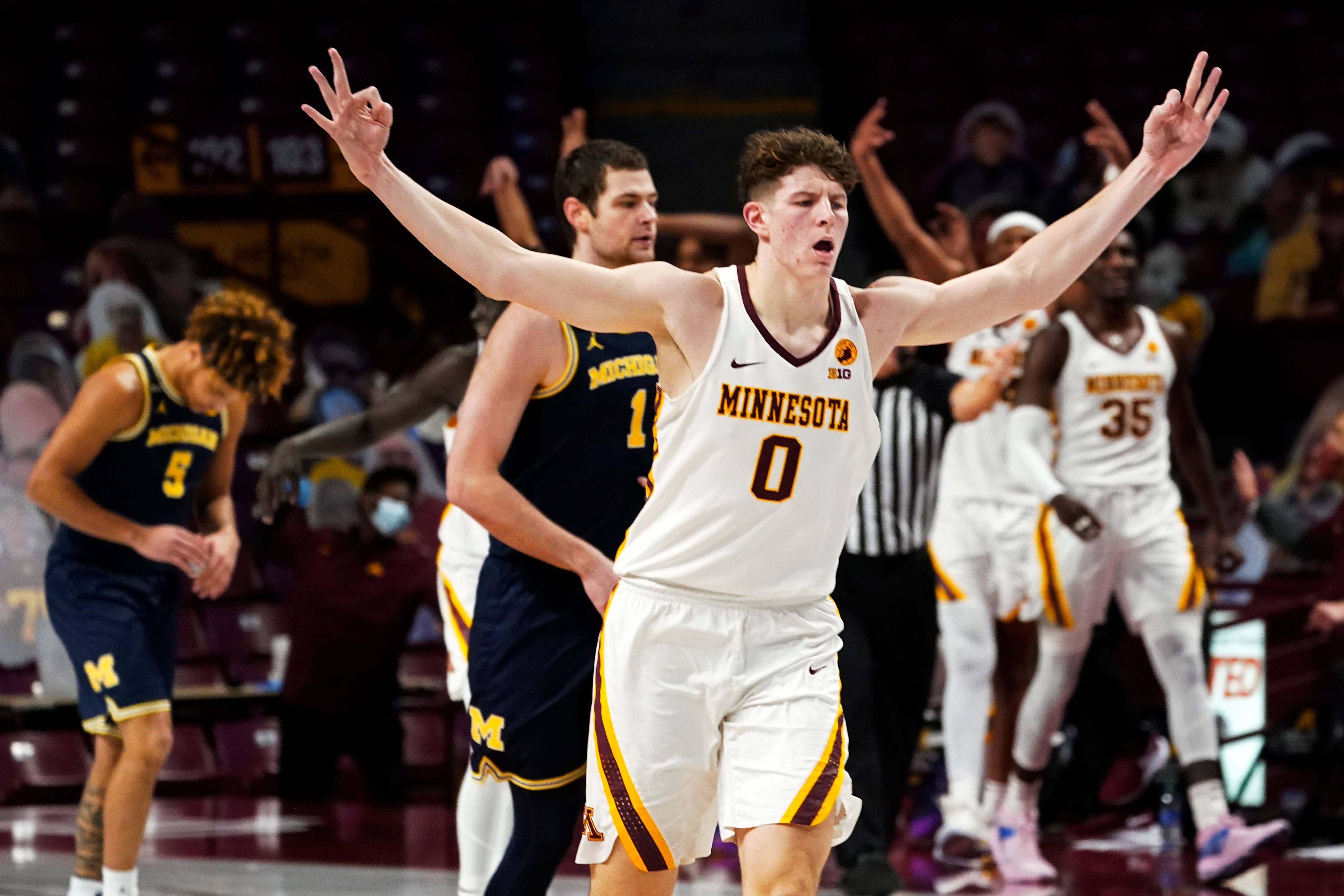 Minnesota's Liam Robbins (0) celebrates his 3-point shot against Michigan in the second half.