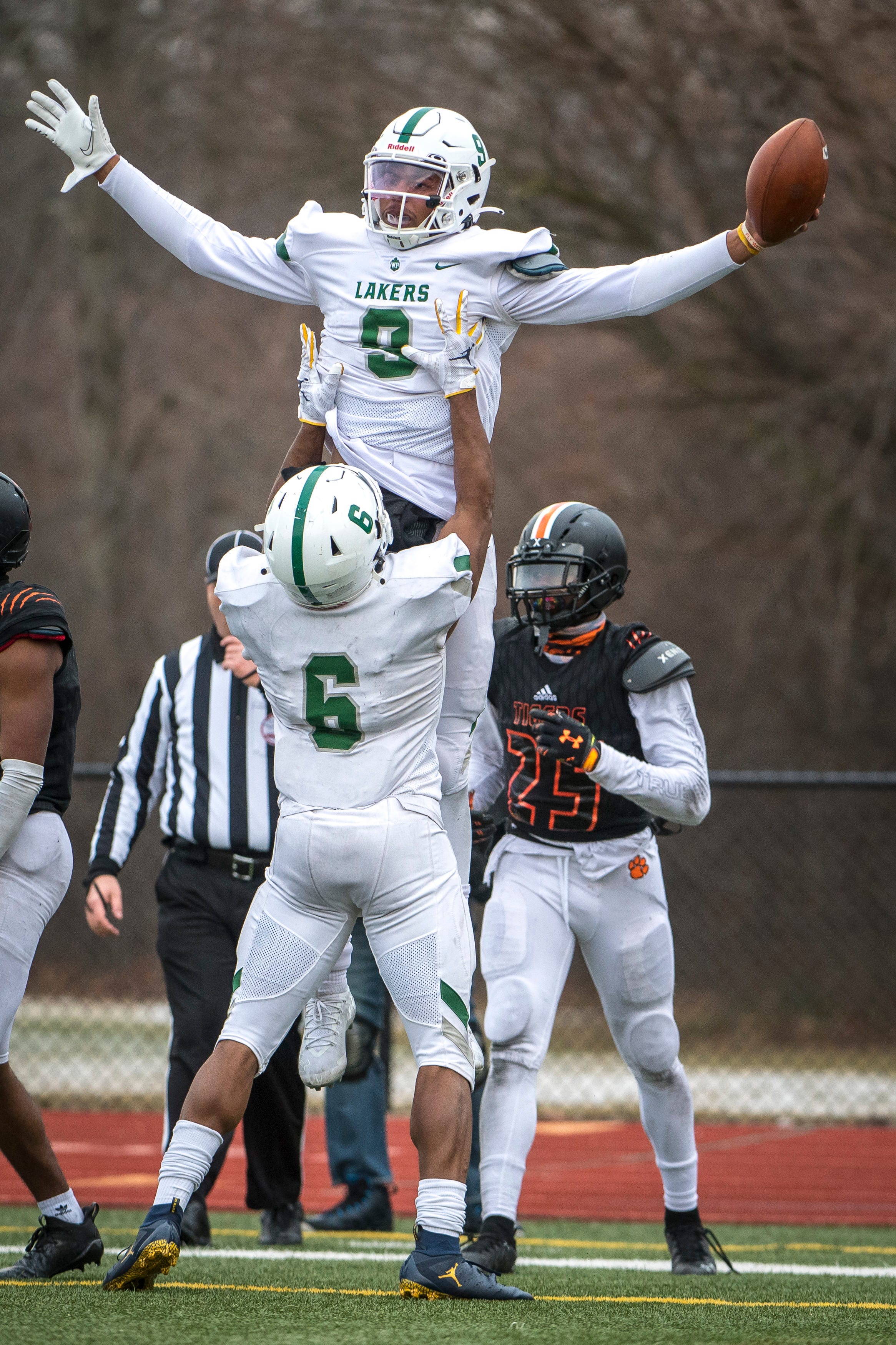 West Bloomfield senior running back Donovan Edwards (6) hoists West Bloomfield senior quarterback Alex Short (9) in the air celebrating a touchdown during the fourth quarter.
