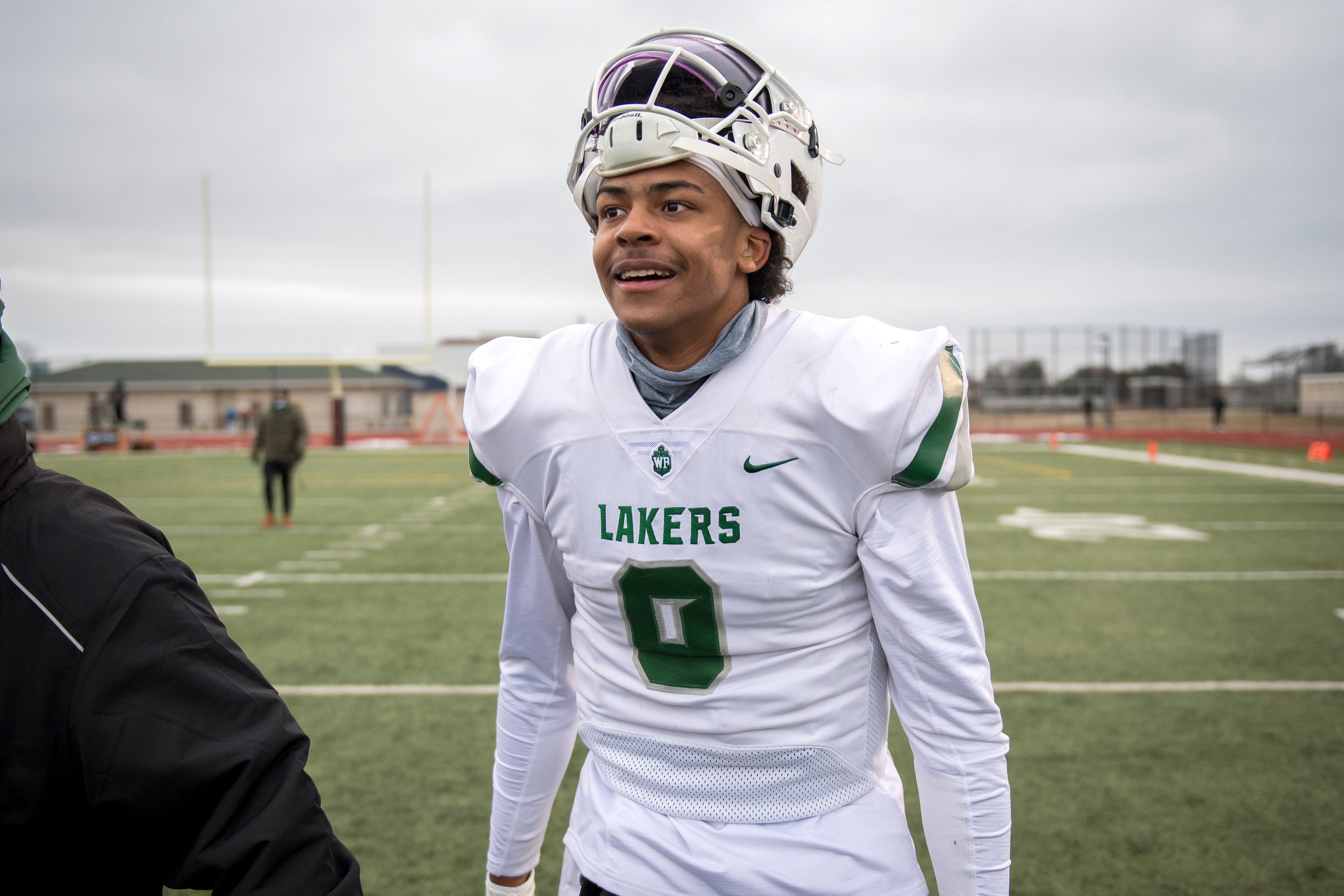 West Bloomfield senior quarterback Alex Short (9) smiles after the Lakers beat Belleville in double overtime, 35-34.
