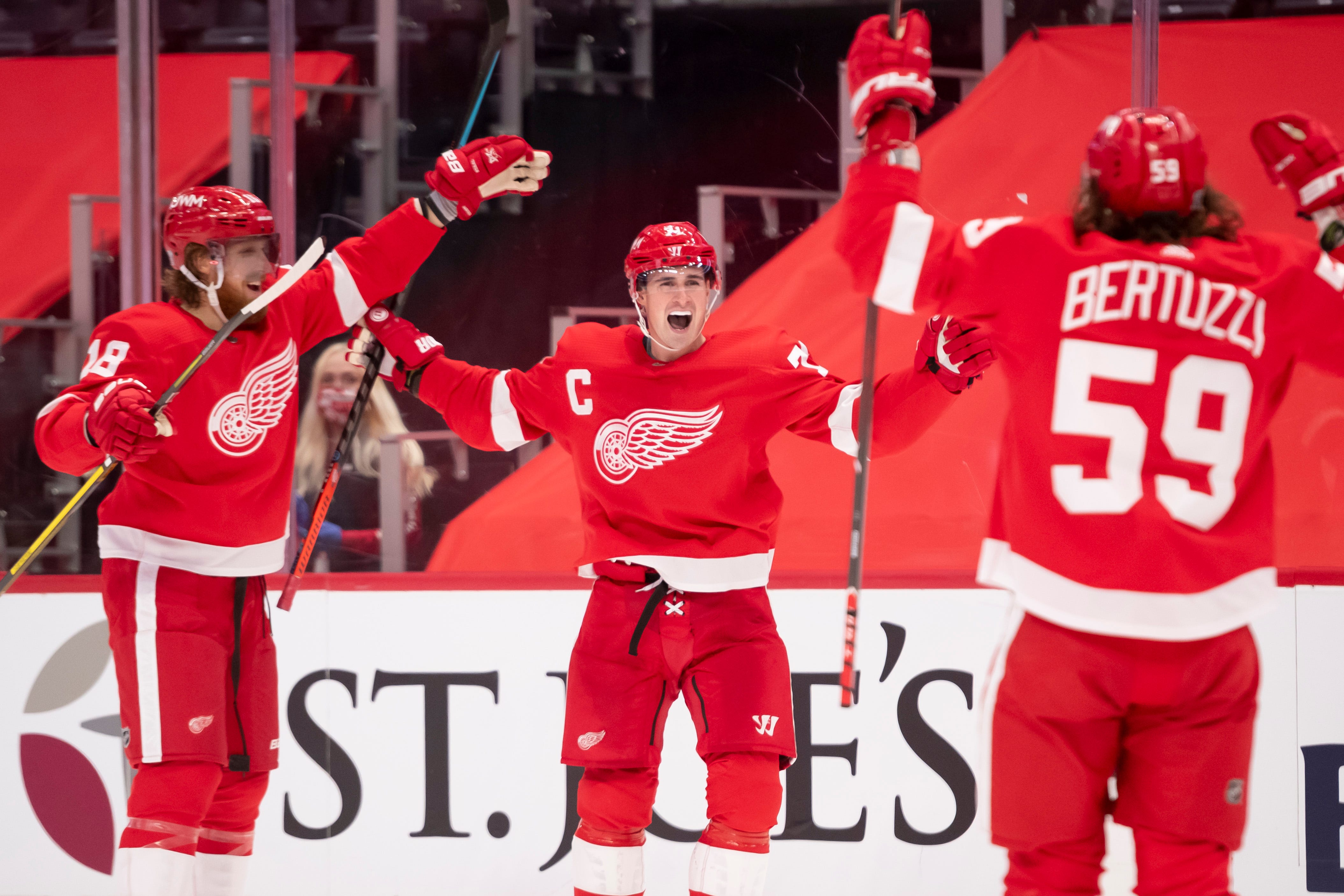 Detroit center Dylan Larkin, center, celebrates after scoring his first goal of the season in the third period during a game between the Detroit Red Wings and the Carolina Hurricanes.
