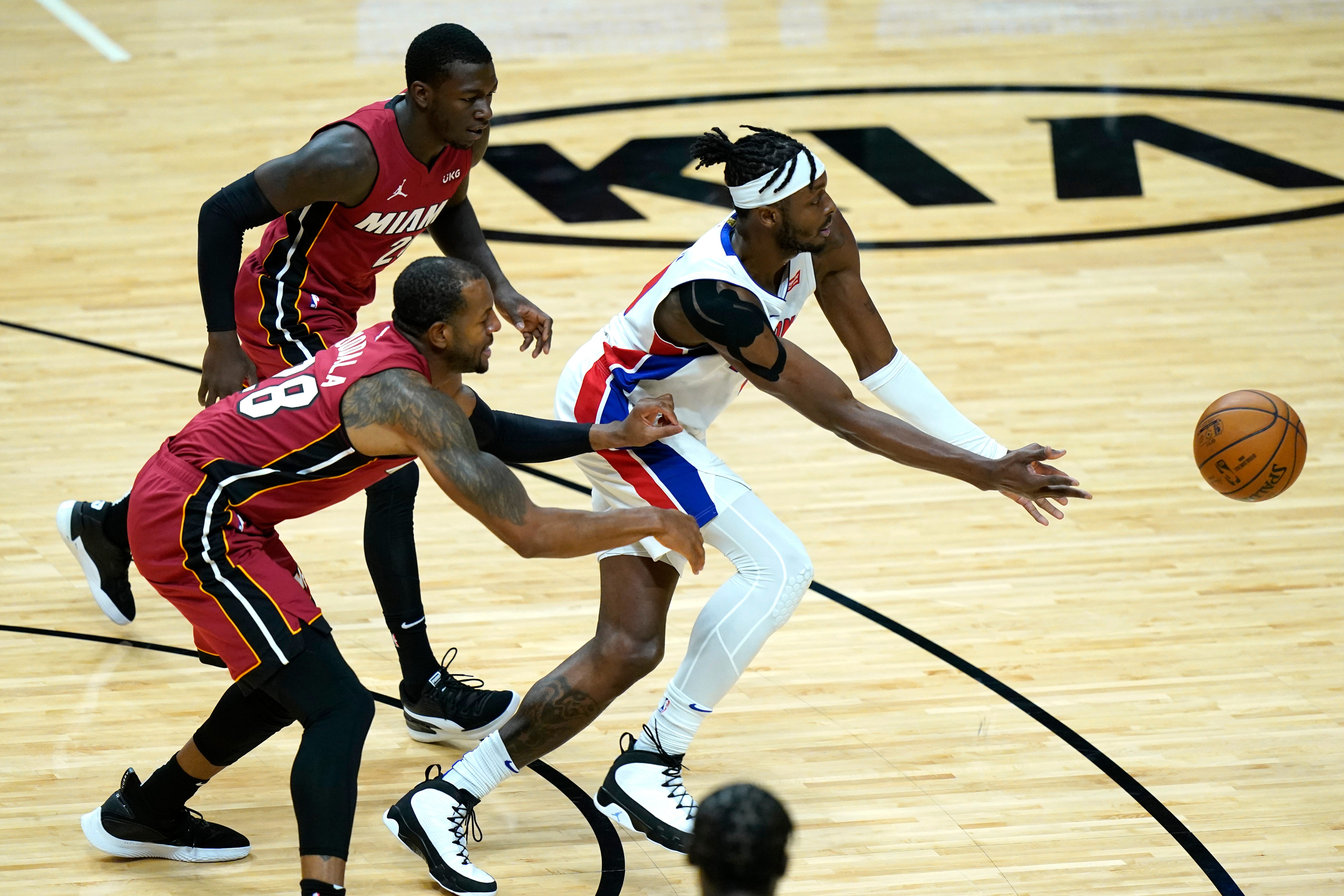 Detroit Pistons forward Jerami Grant, right passes as Miami Heat forward Andre Iguodala, left, defends during the first half.