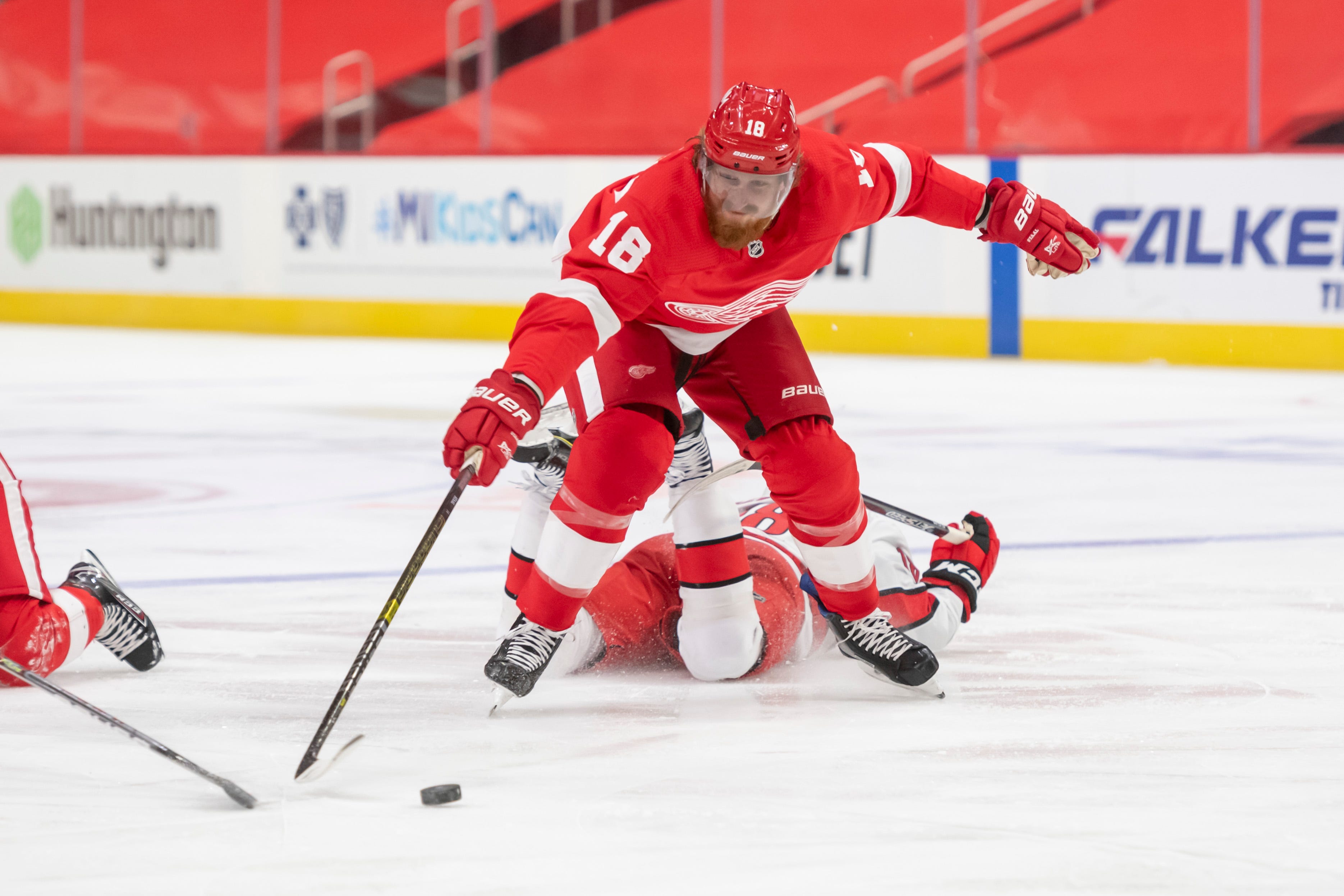 Detroit defenseman Marc Staal skates around a fallen Carolina center Ryan Dzingel while battling for the puck in the second period.