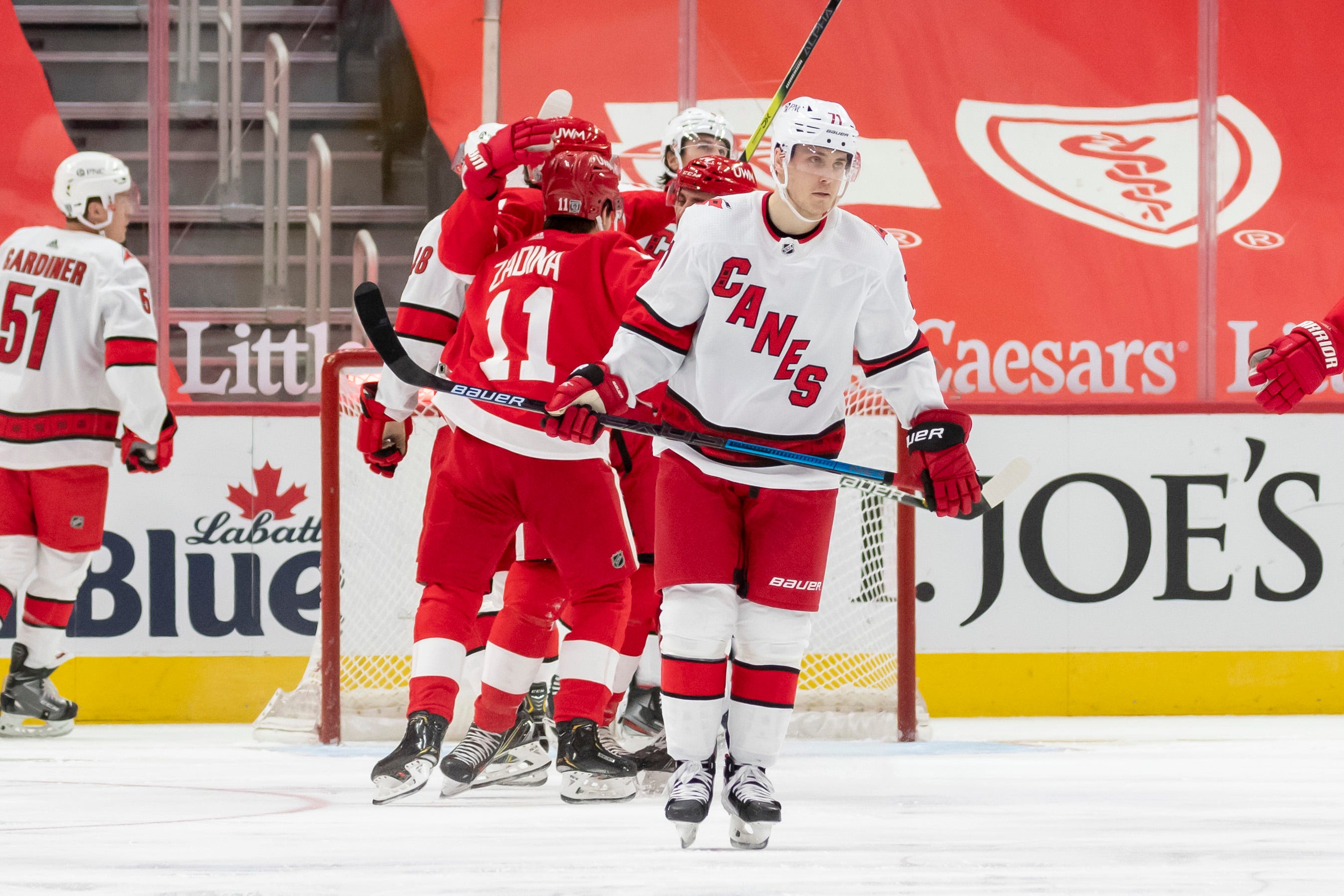 Carolina right wing Jesper Fast looks away as Detroit celebrates a goal by right wing Bobby Ryan in the second period.