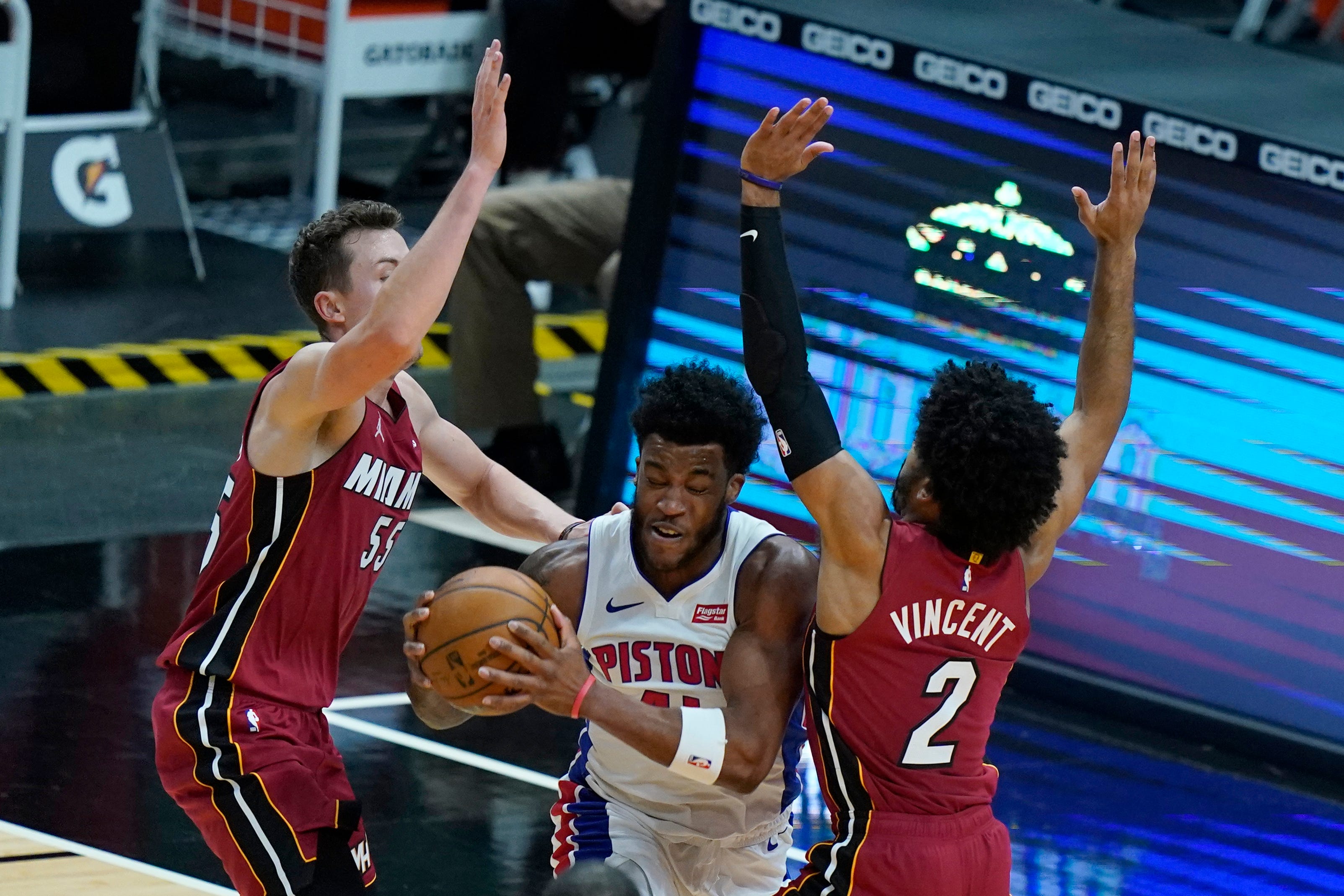 Detroit Pistons forward Saddiq Bey, center, is fouled by Miami Heat guard Gabe Vincent (2) during the second half.