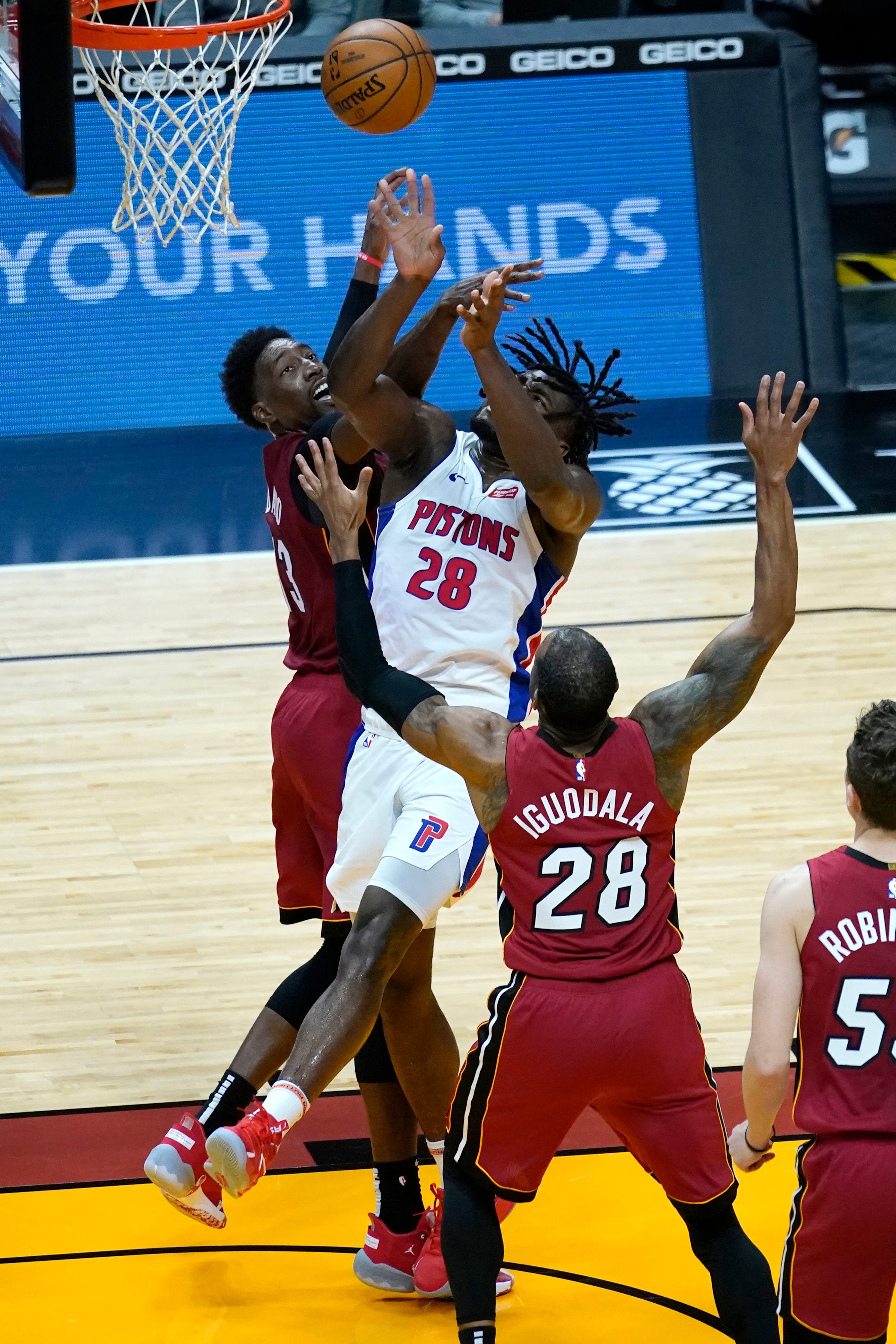 Detroit Pistons center Isaiah Stewart (28) shoots as Miami Heat center Bam Adebayo, left, and forward Andre Iguodala,, right, defend during the first half.