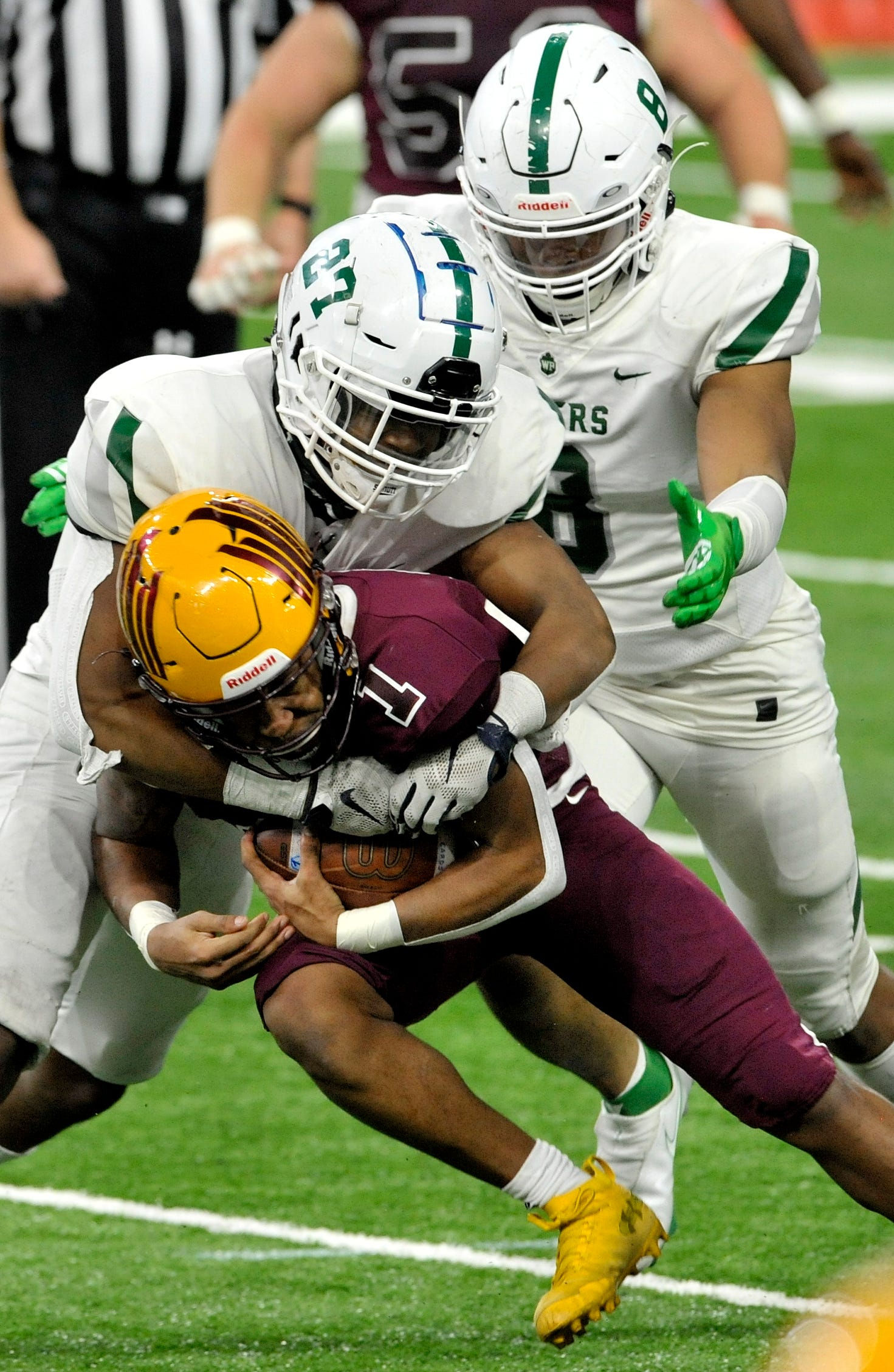 Davison Dion Brown Jr. (1) keeps the ball as he rushes for a first down in the third quarter while being tackled by West Bloomfield's Kyle Johnson (27) and Chris Johnson.