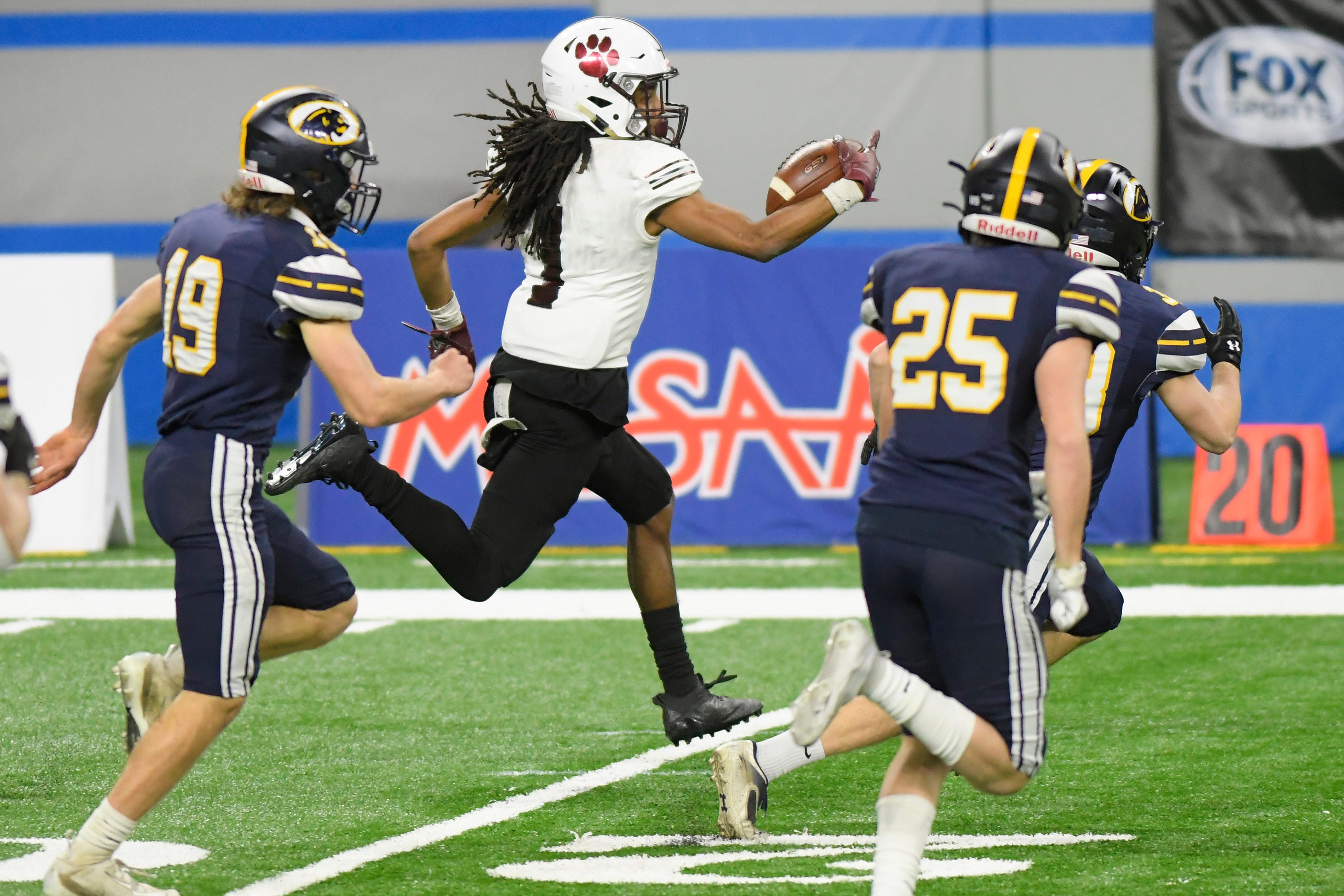River Rouge kick returner Davion Haynes runs back a kickoff against DeWitt in the first quarter of a Division 3 football final held at Ford Field.