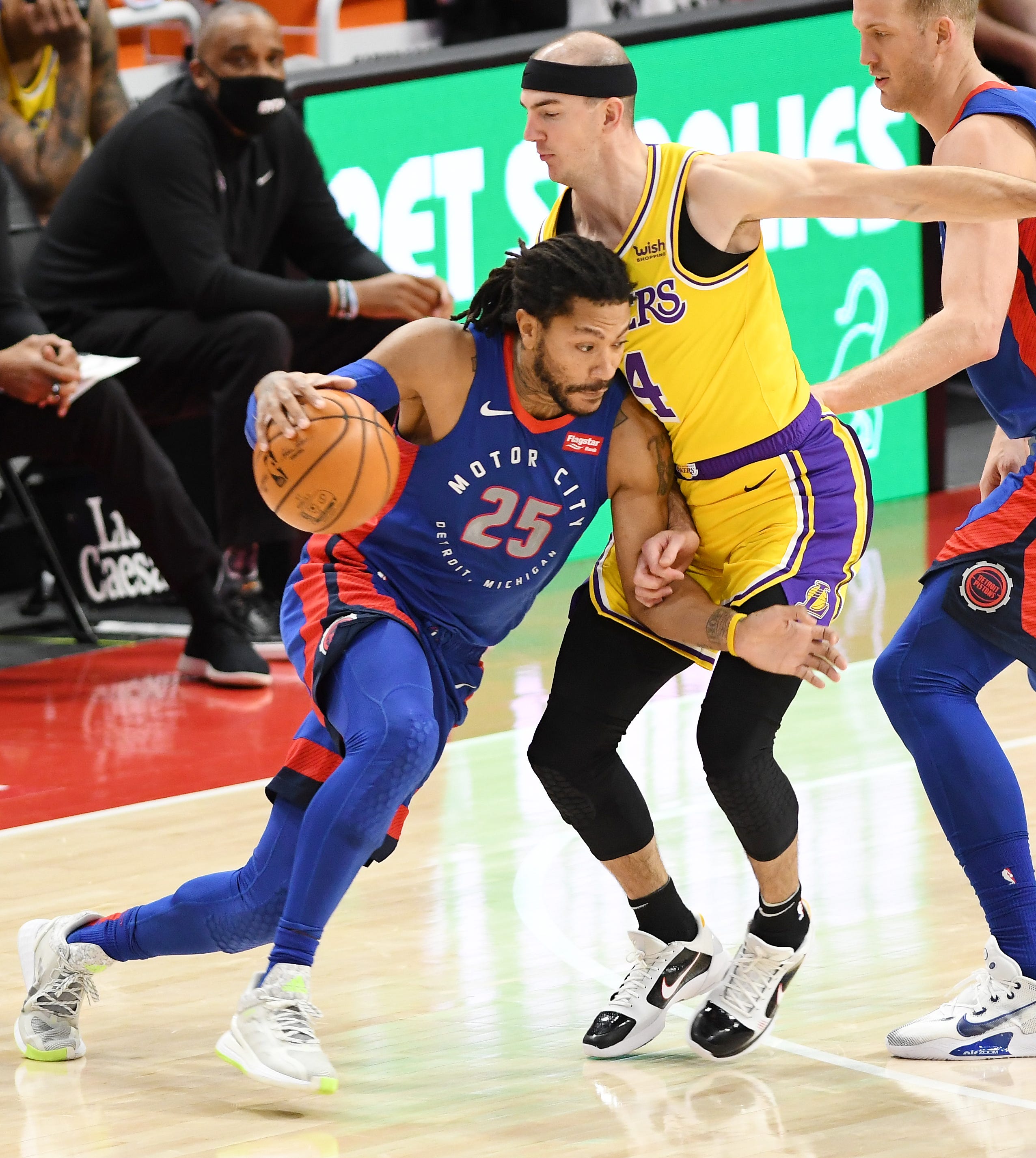 Pistons' Derrick Rose drives around Lakers' Alex Caruso in the fourth quarter.