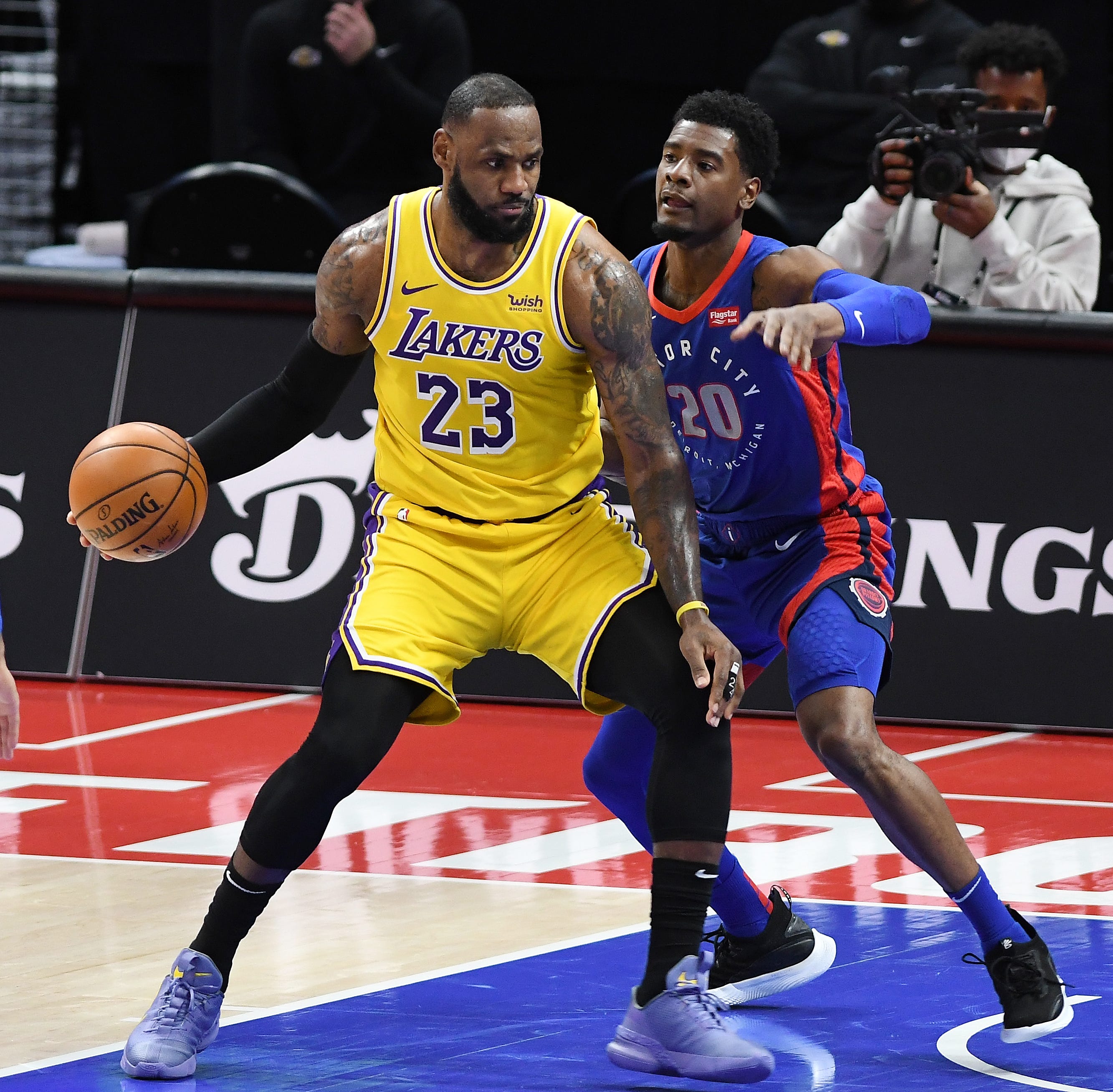 Lakers' LeBron James looks for room around Pistons' Josh Jackson in the second quarter.
