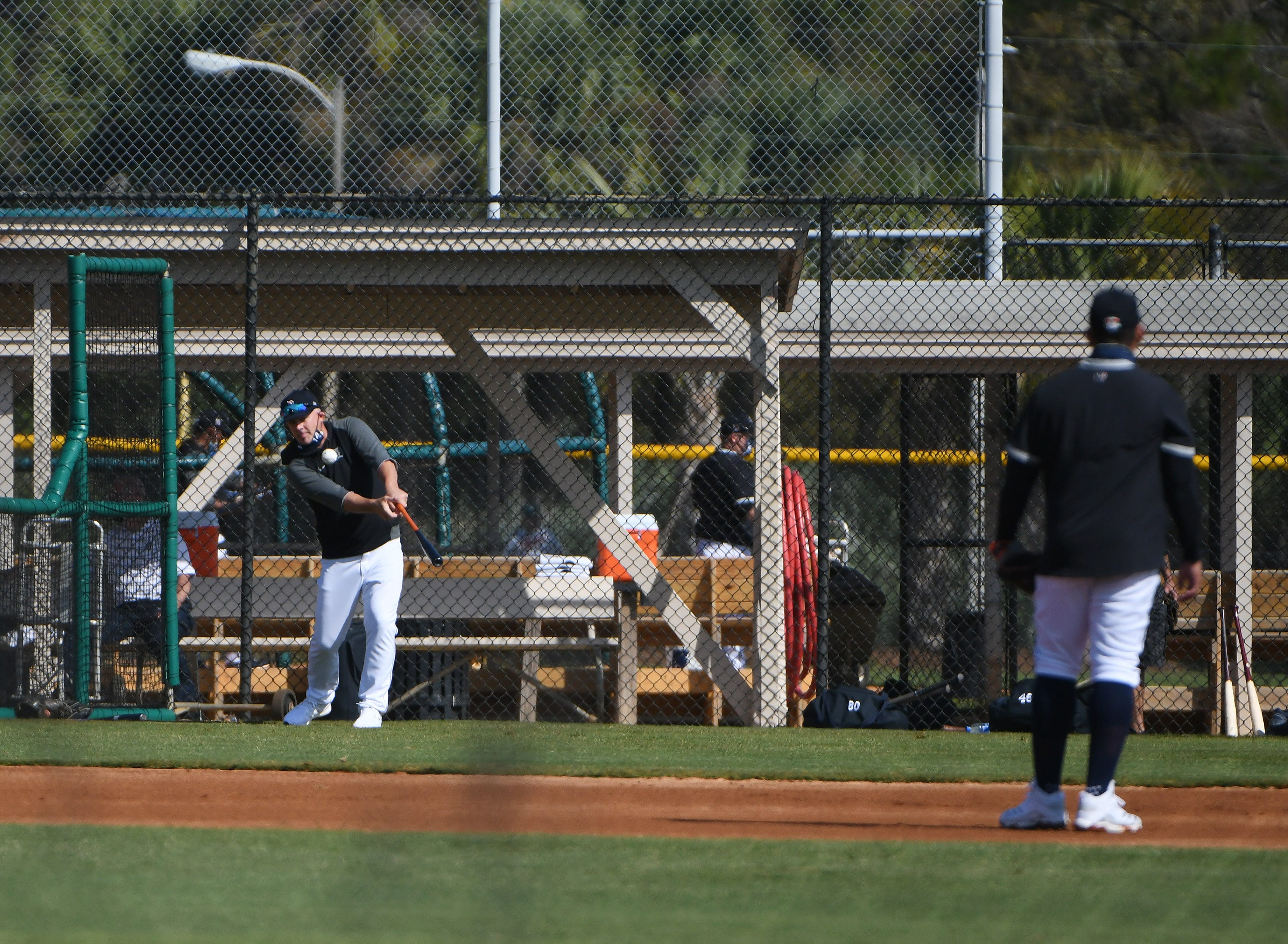 Tigers manager AJ Hinch hits ground balls during infield practice.