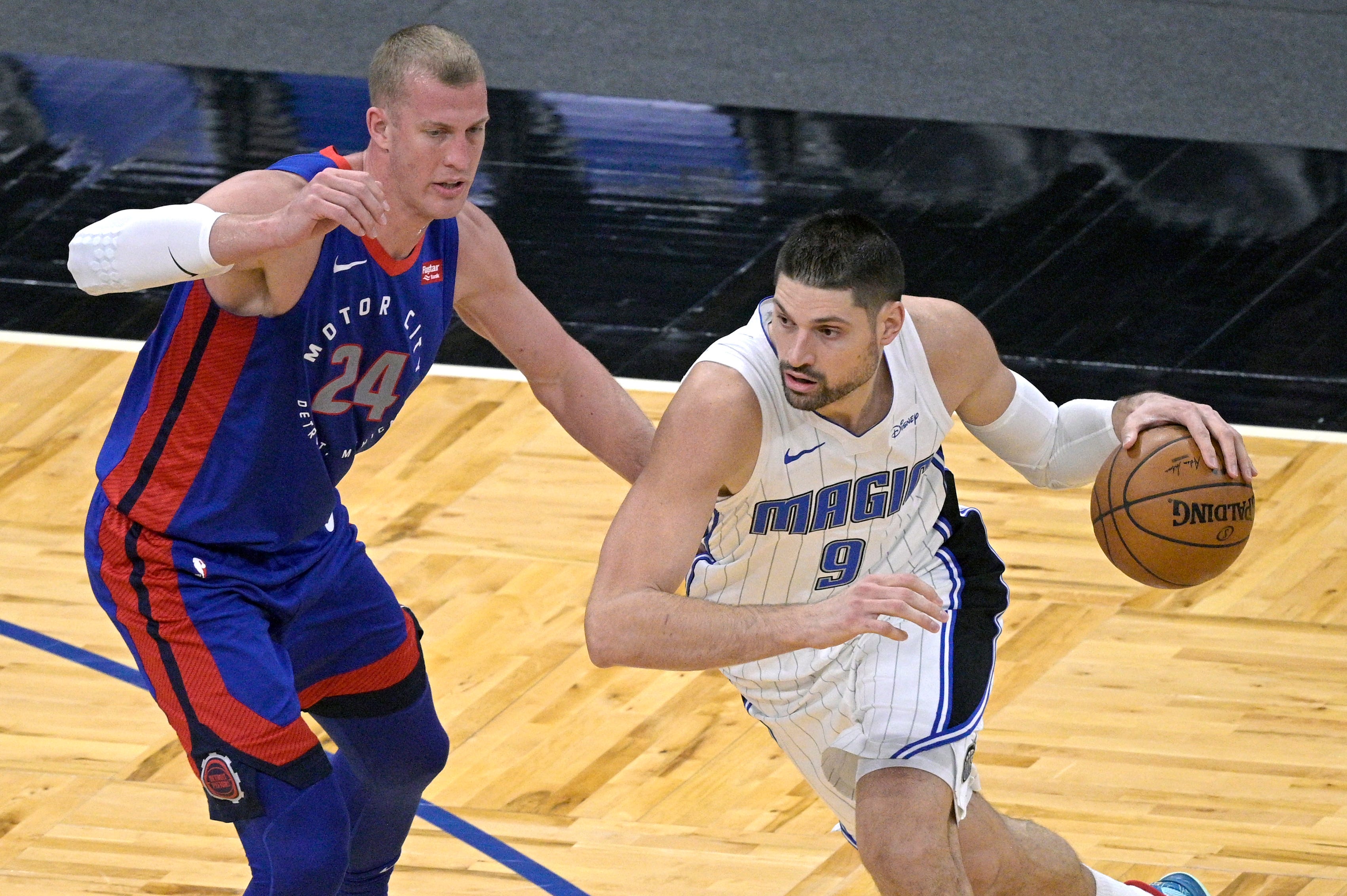 Orlando Magic center Nikola Vucevic (9) drives to the basket in front of Detroit Pistons center Mason Plumlee (24) during the first half of an NBA basketball game, Tuesday, Feb. 23, 2021, in Orlando, Fla.