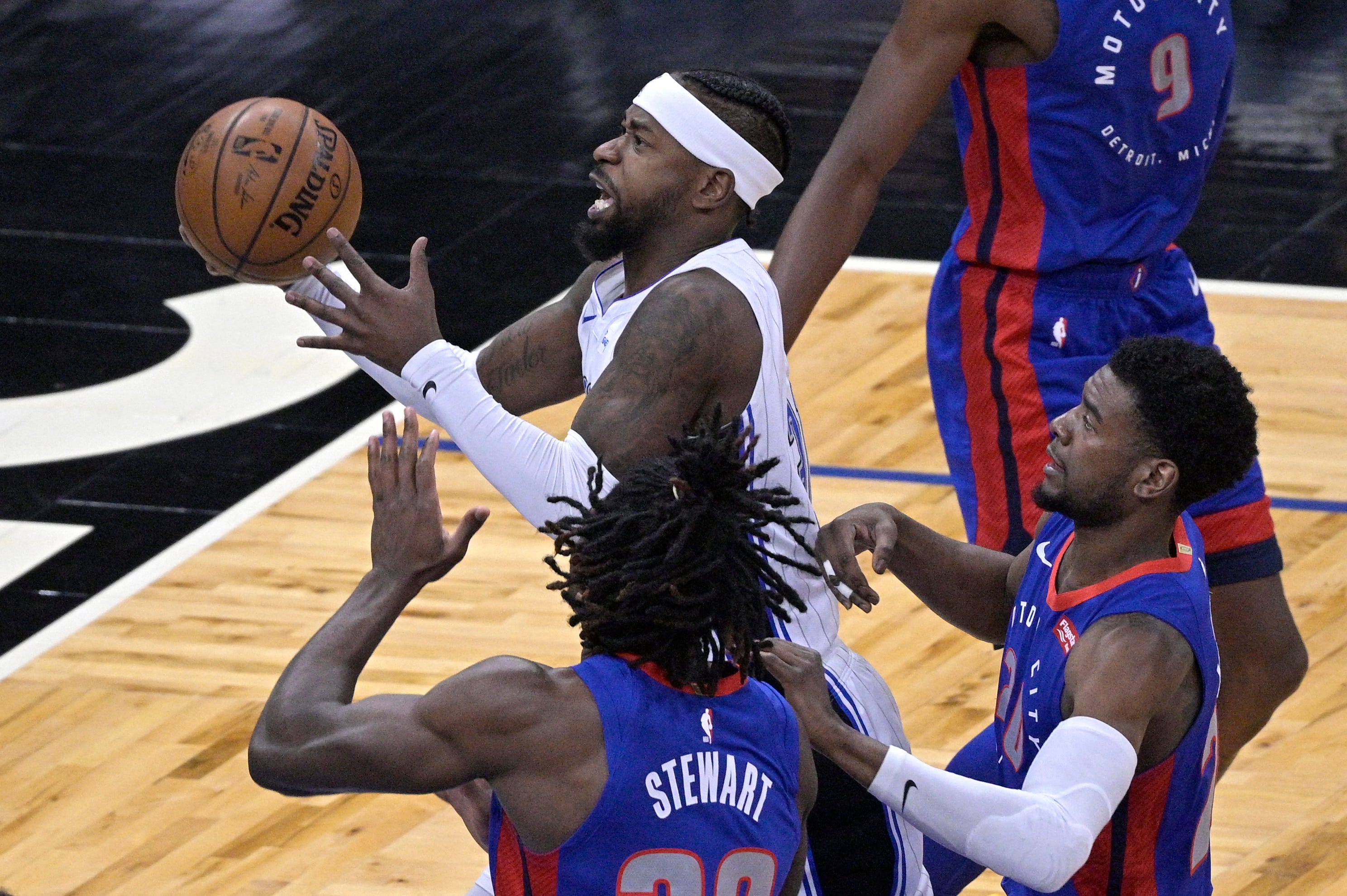 Orlando Magic guard Terrence Ross, center, goes up for a shot in front of Detroit Pistons center Isaiah Stewart, left, and guard Josh Jackson, right, during the first half of an NBA basketball game.