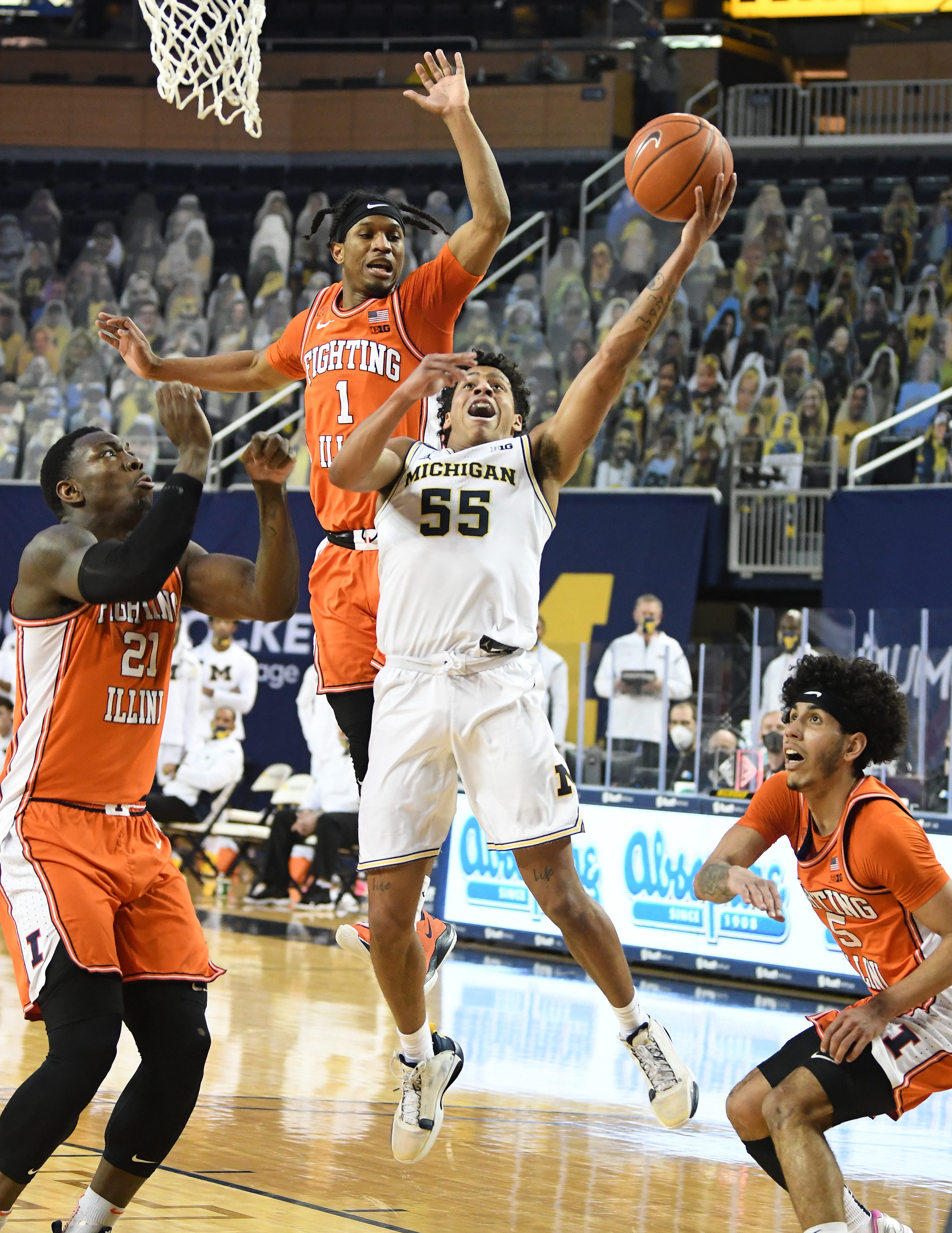 Michigan's Ei Brooks drives to the basket against Illinois' defense in the first half.