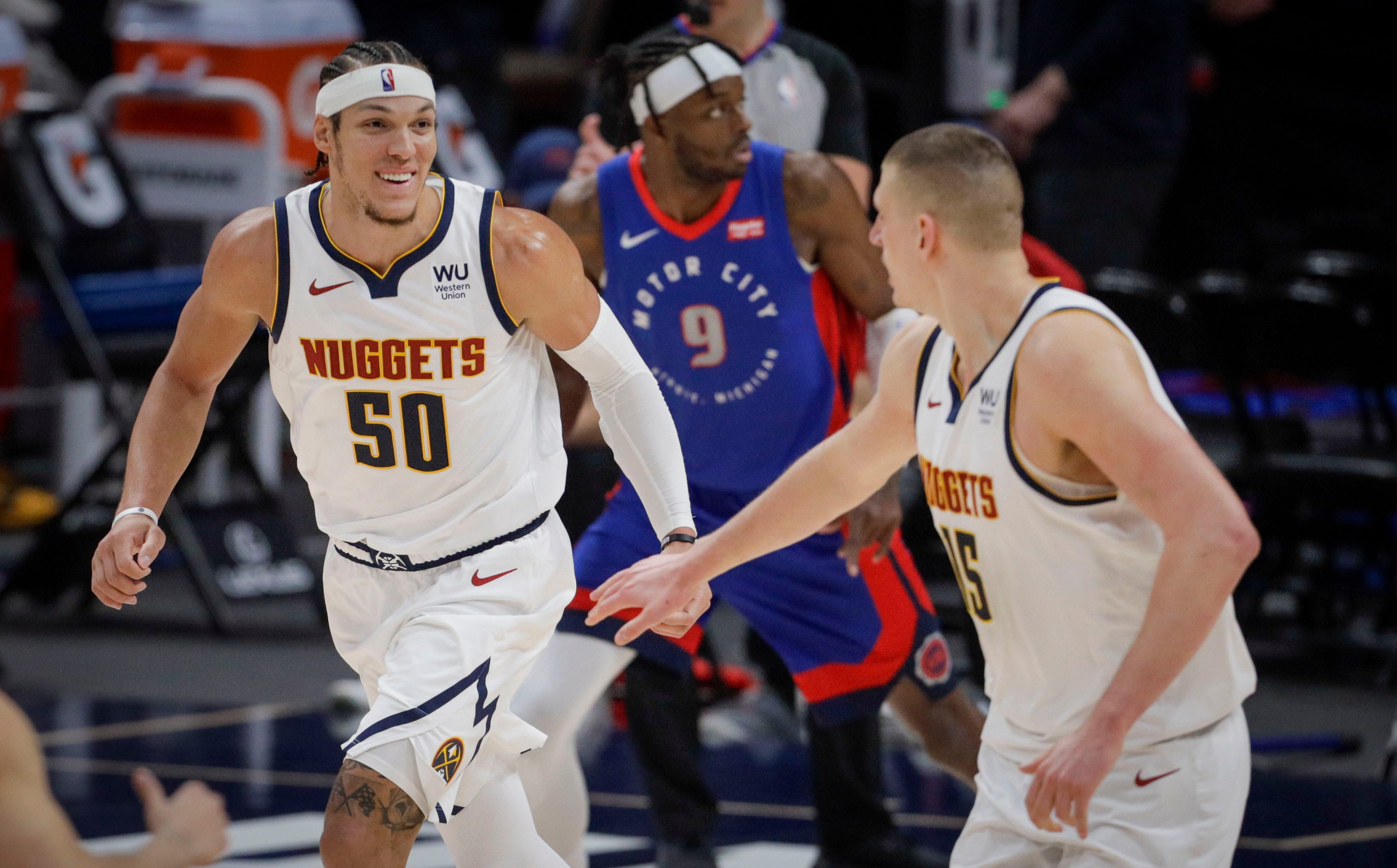 Denver Nuggets forward Aaron Gordon (50) smiles as he runs back up the court with center Nikola Jokic (15) in the third quarter of an NBA basketball game against the Detroit Pistons in Denver, Tuesday, April 6, 2021.