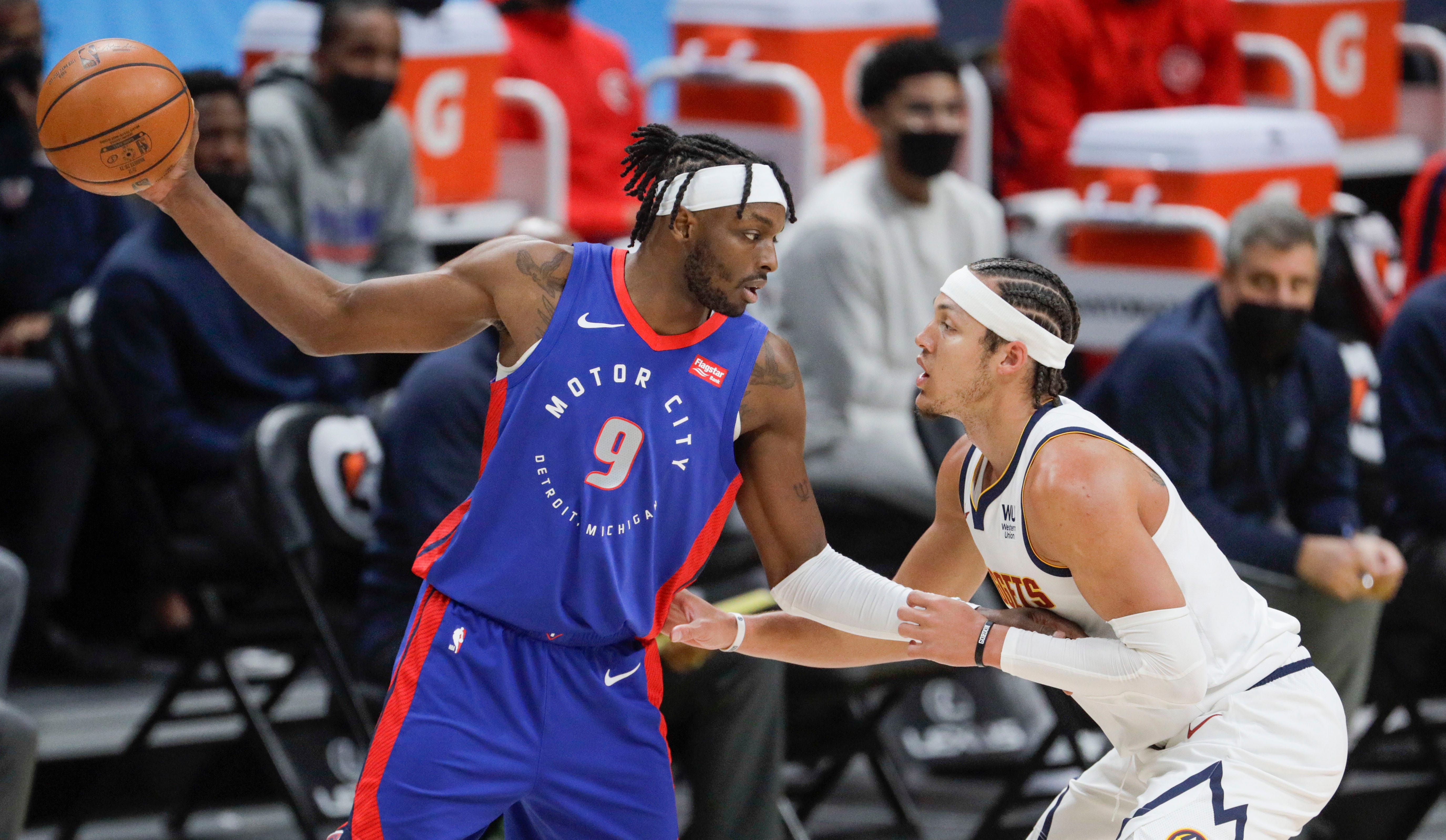 Detroit Pistons forward Jerami Grant (9) holds the ball away from Denver Nuggets forward Aaron Gordon (50) in the first quarter of an NBA basketball game in Denver, Tuesday, April 6, 2021.