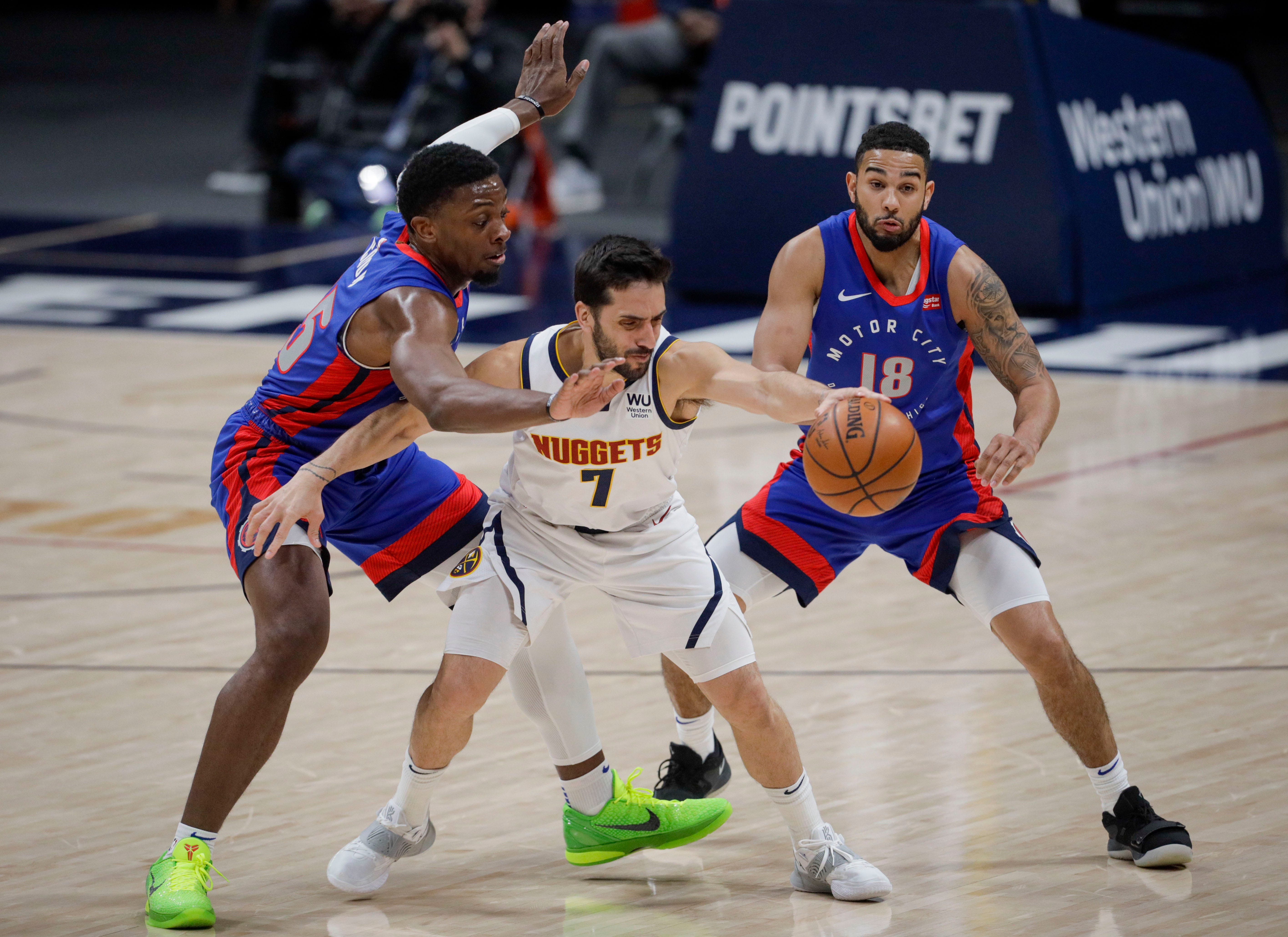 Detroit Pistons forward Tyler Cook, left, and guard Cory Joseph (18) pressure Denver Nuggets guard Facundo Campazzo (7) in the fourth quarter of an NBA basketball game in Denver, Tuesday, April 6, 2021. Denver won 134-119.