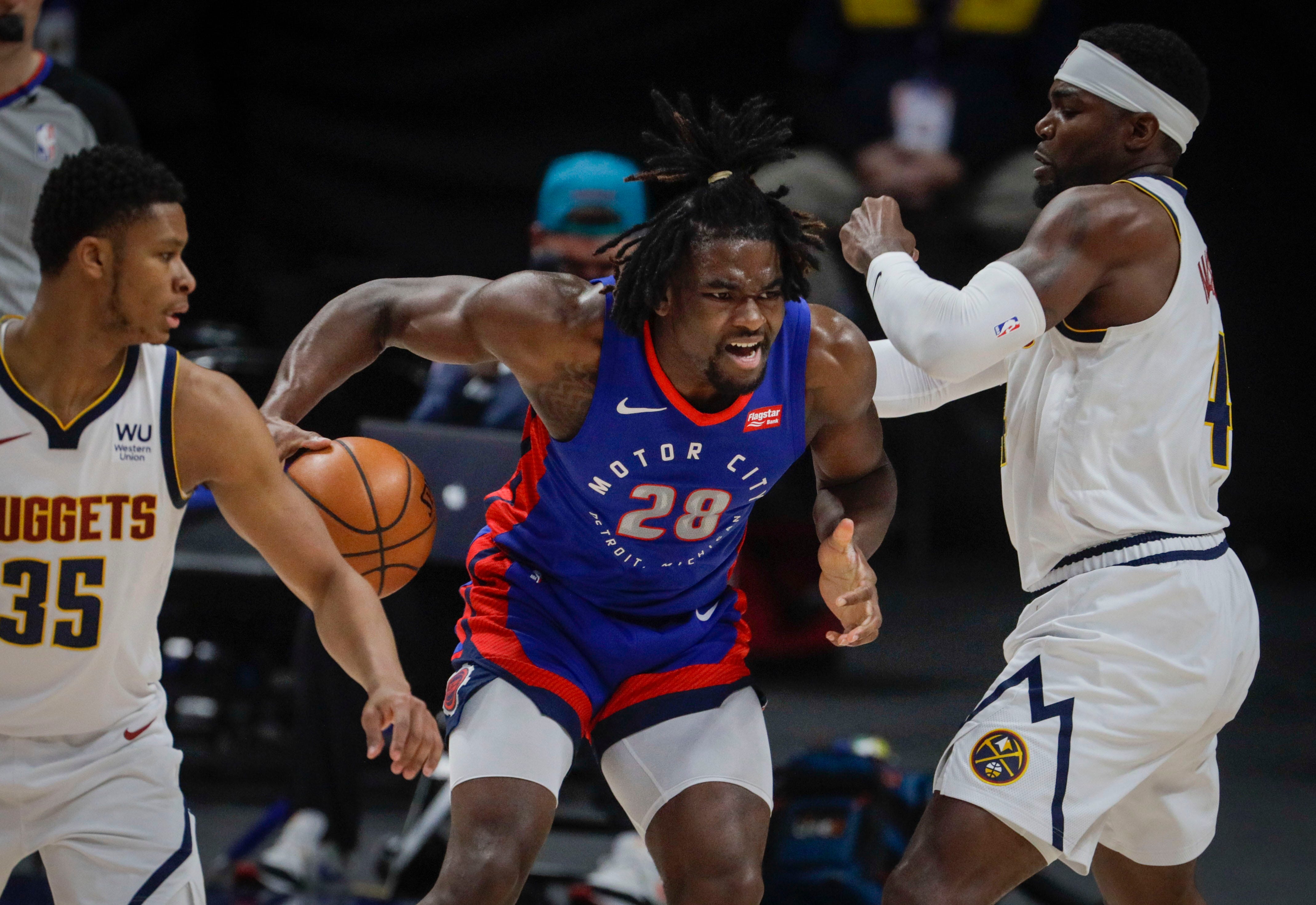 Detroit Pistons center Isaiah Stewart (28) gets position against Denver Nuggets forward Paul Millsap (4) and guard PJ Dozier (35) in the second quarter of an NBA basketball game in Denver, Tuesday, April 6, 2021.