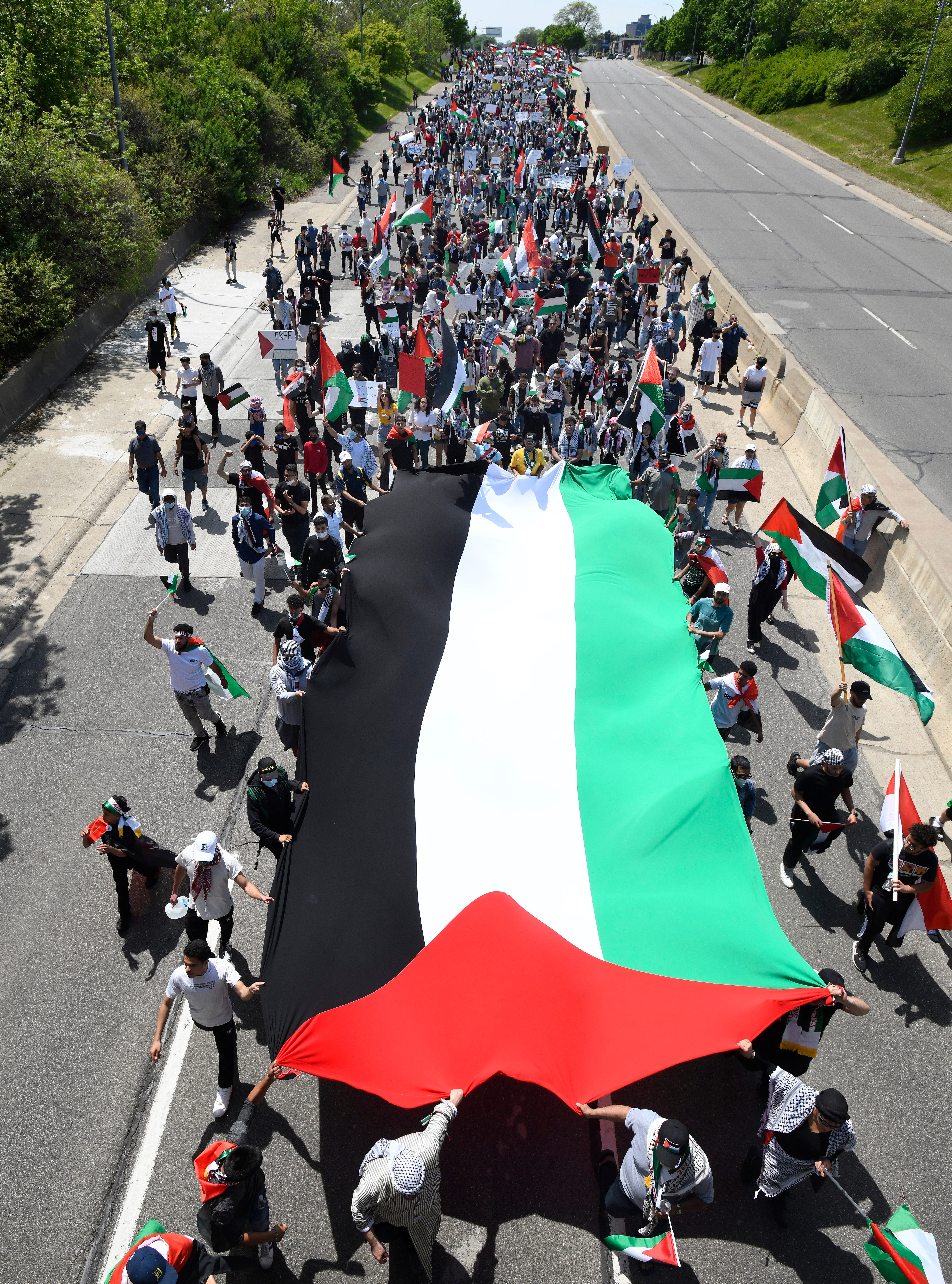 A huge Palestinian flag followed by thousands of Palestinian supporters march down eastbound Michigan Avenue during a Palestinian protest and march, at the same time President Joe Biden is visiting in another part of Dearborn, Michigan on May 18, 2021.