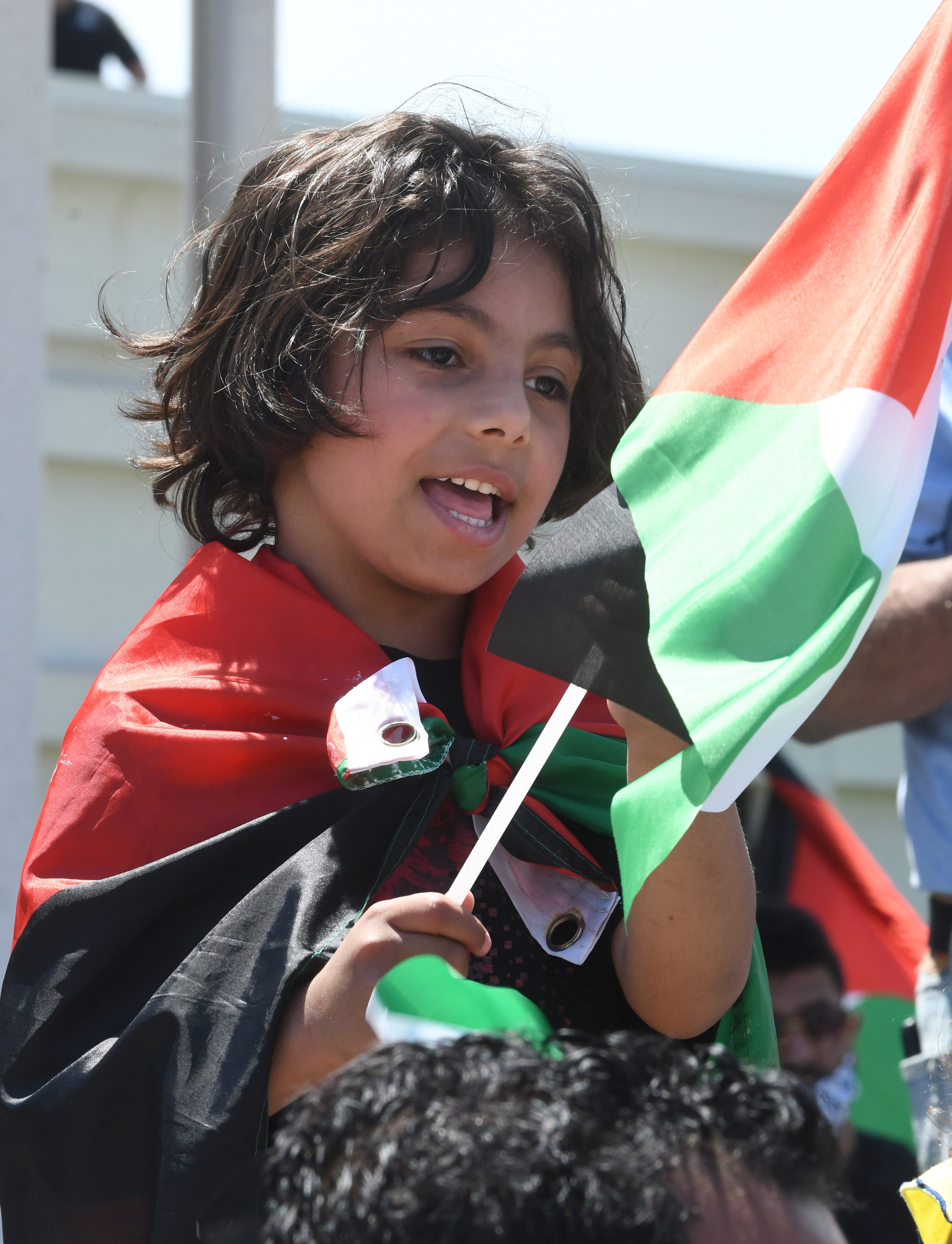 A young boy wrapped in a Palestinian flag during a Palestinian protest and march, at the same time President Joe Biden is visiting in another part of Dearborn, Michigan on May 18, 2021.