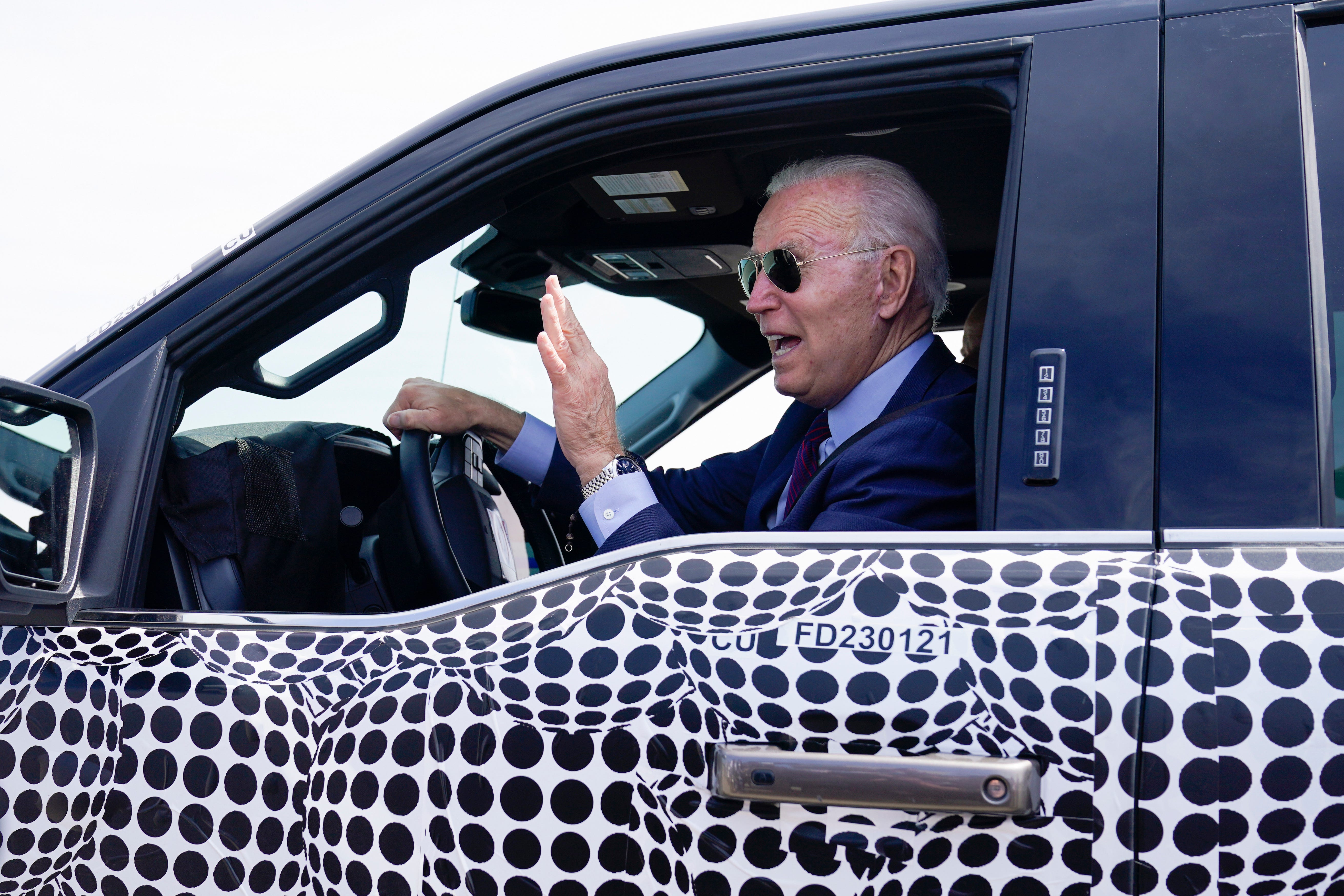 President Joe Biden stops to talk to the media as he drives a Ford F-150 Lightning truck at Ford Dearborn Development Center, Tuesday, May 18, 2021, in Dearborn, Mich.