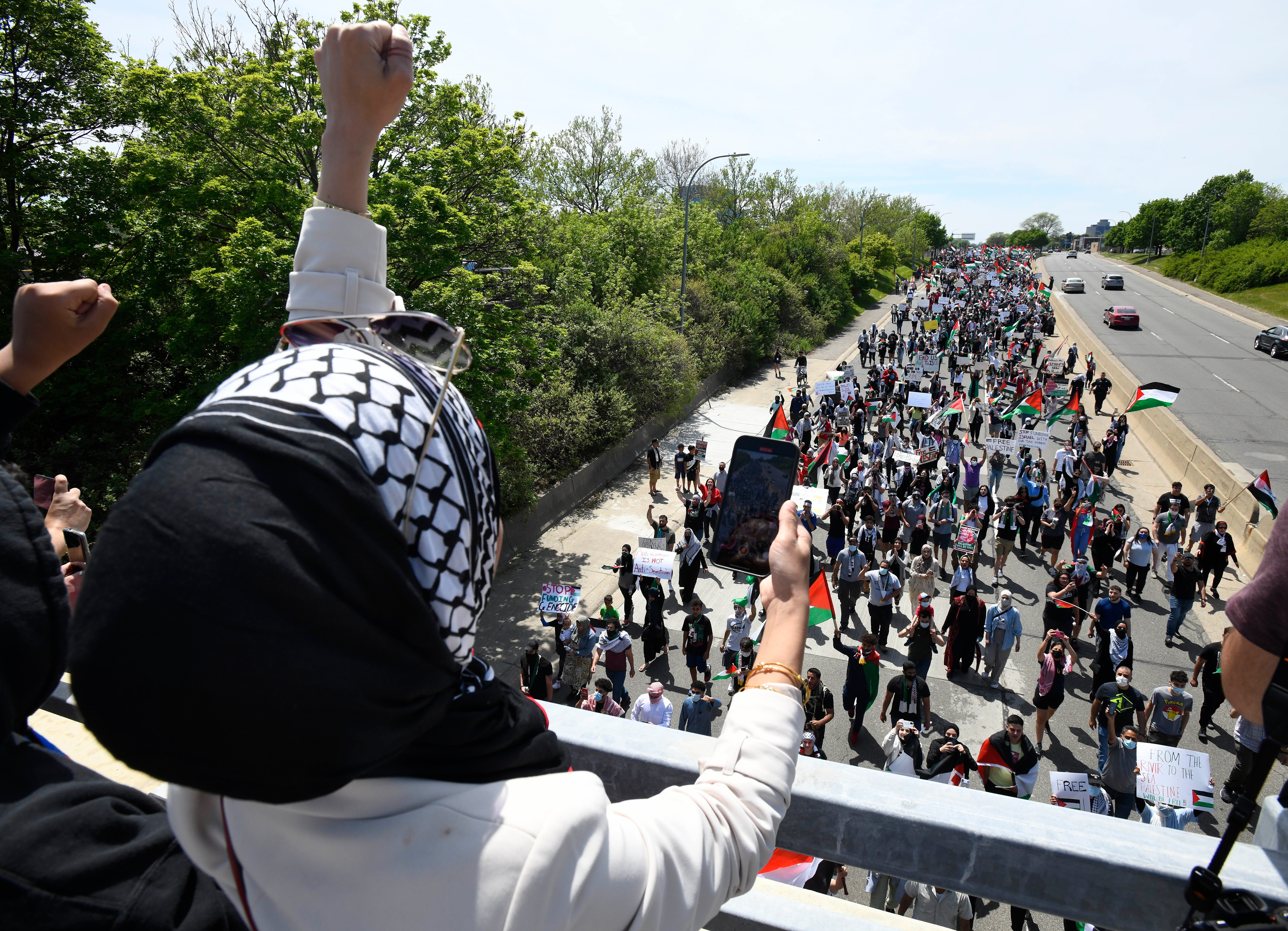 Ola Ali raises her fist in support as thousands of Palestinian supporters march down eastbound Michigan Avenue during a Palestinian protest and march, at the same time President Joe Biden is visiting in another part of Dearborn, Michigan on May 18, 2021.