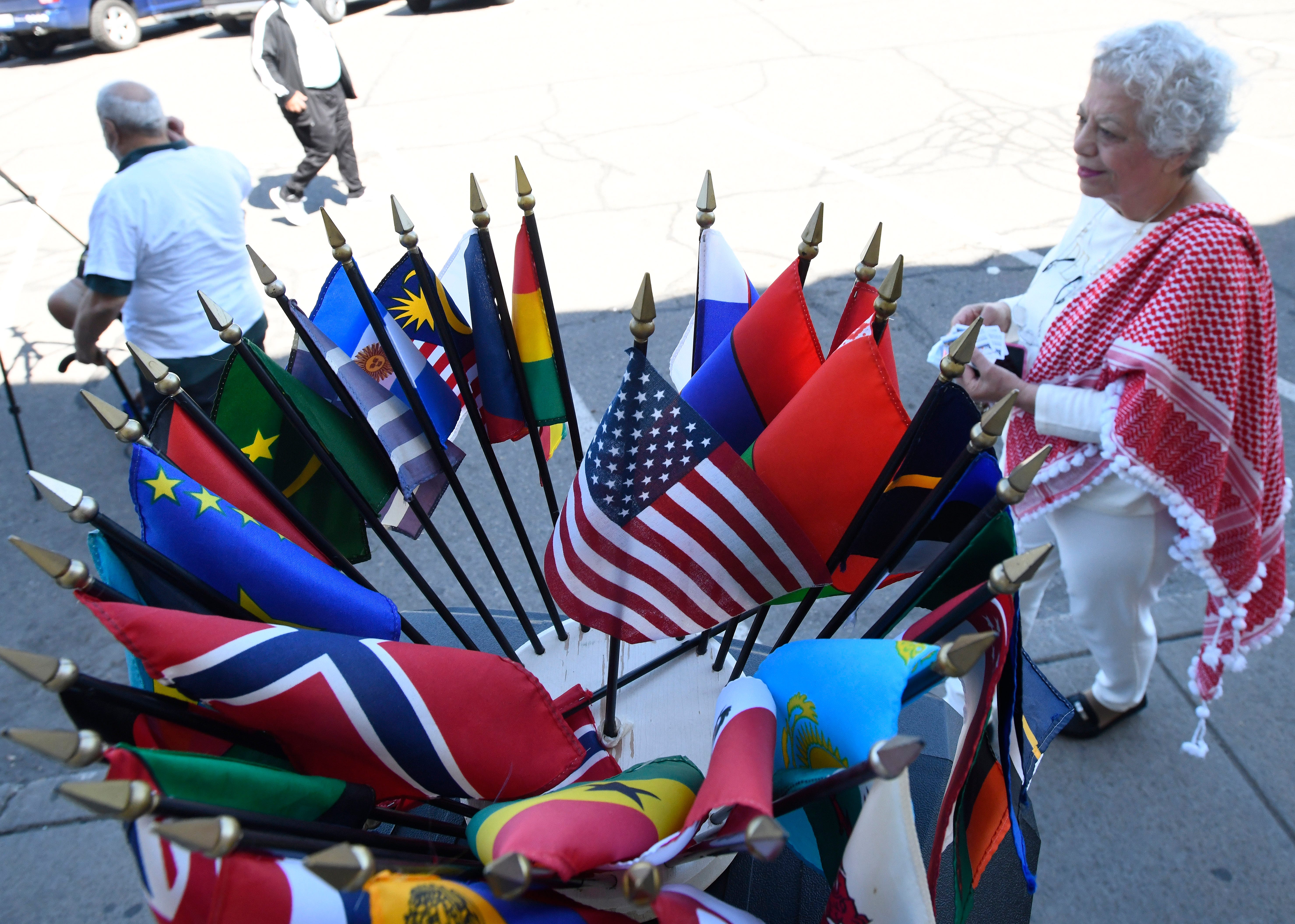 Nada Dalgamouni, global education director of the International Institute of Metropolitan Detroit, Inc. brings a bouquet of flags of countries to the news conference, "The flags represent to you, that the whole world is saying the same thing, enough is enough."