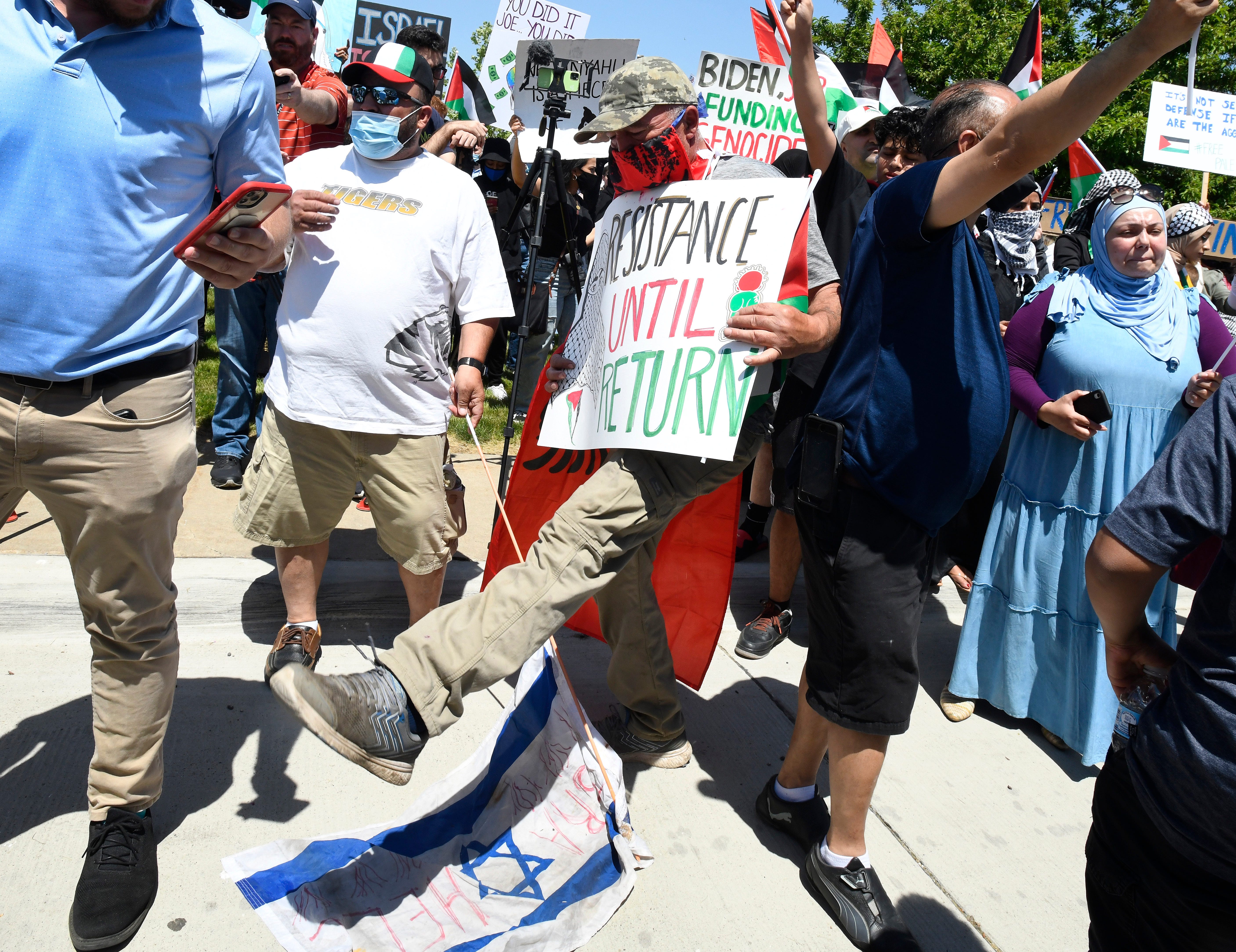 A man stomps on an small Israeli flag during a Palestinian protest and march, at the same time President Joe Biden is visiting in another part of Dearborn, Michigan on May 18, 2021.