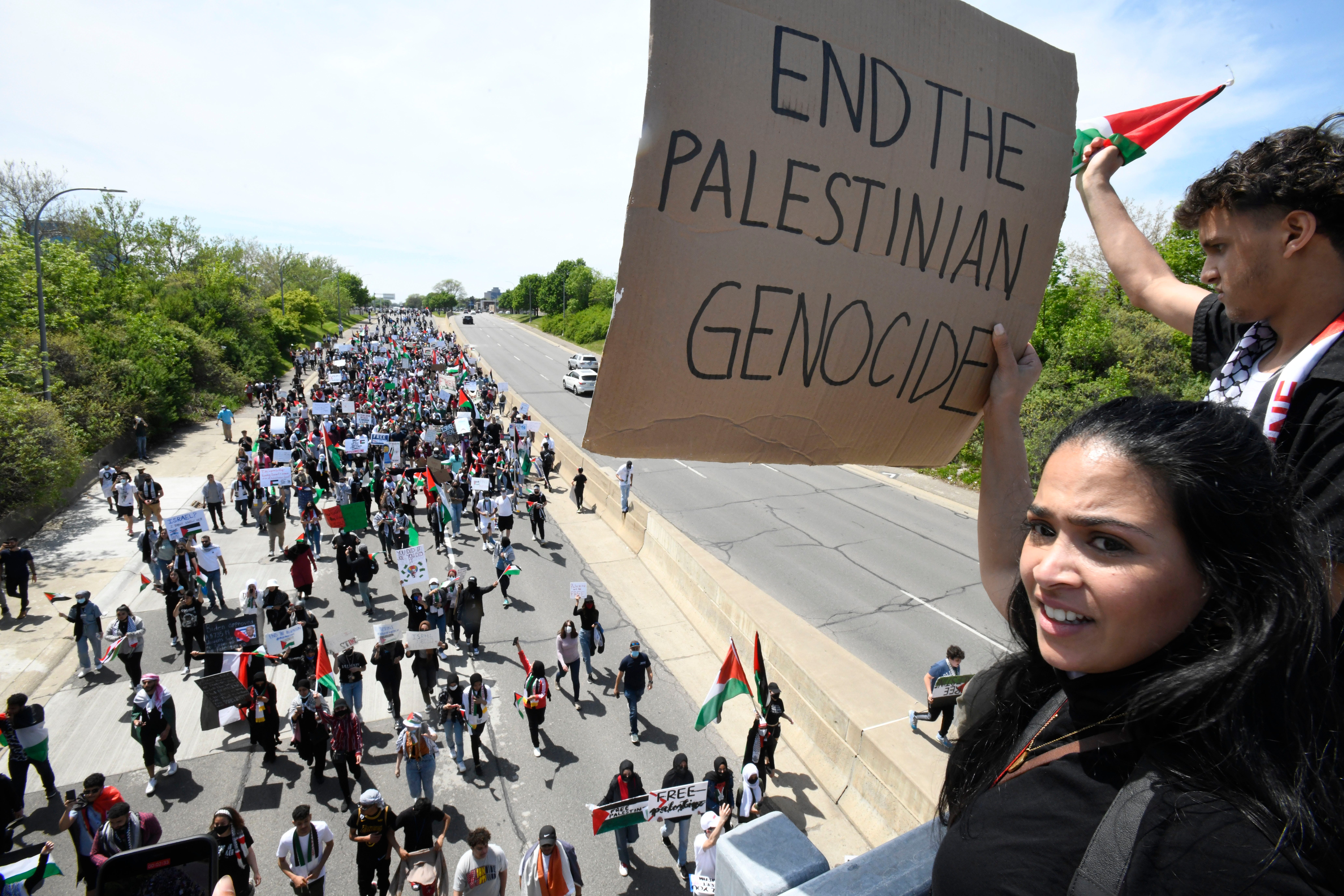 Shema Aman shows her support from an overpass as thousands of Palestinian supporters march down eastbound Michigan Avenue during a Palestinian protest and march, at the same time President Joe Biden is visiting in another part of Dearborn, Michigan on May 18, 2021.