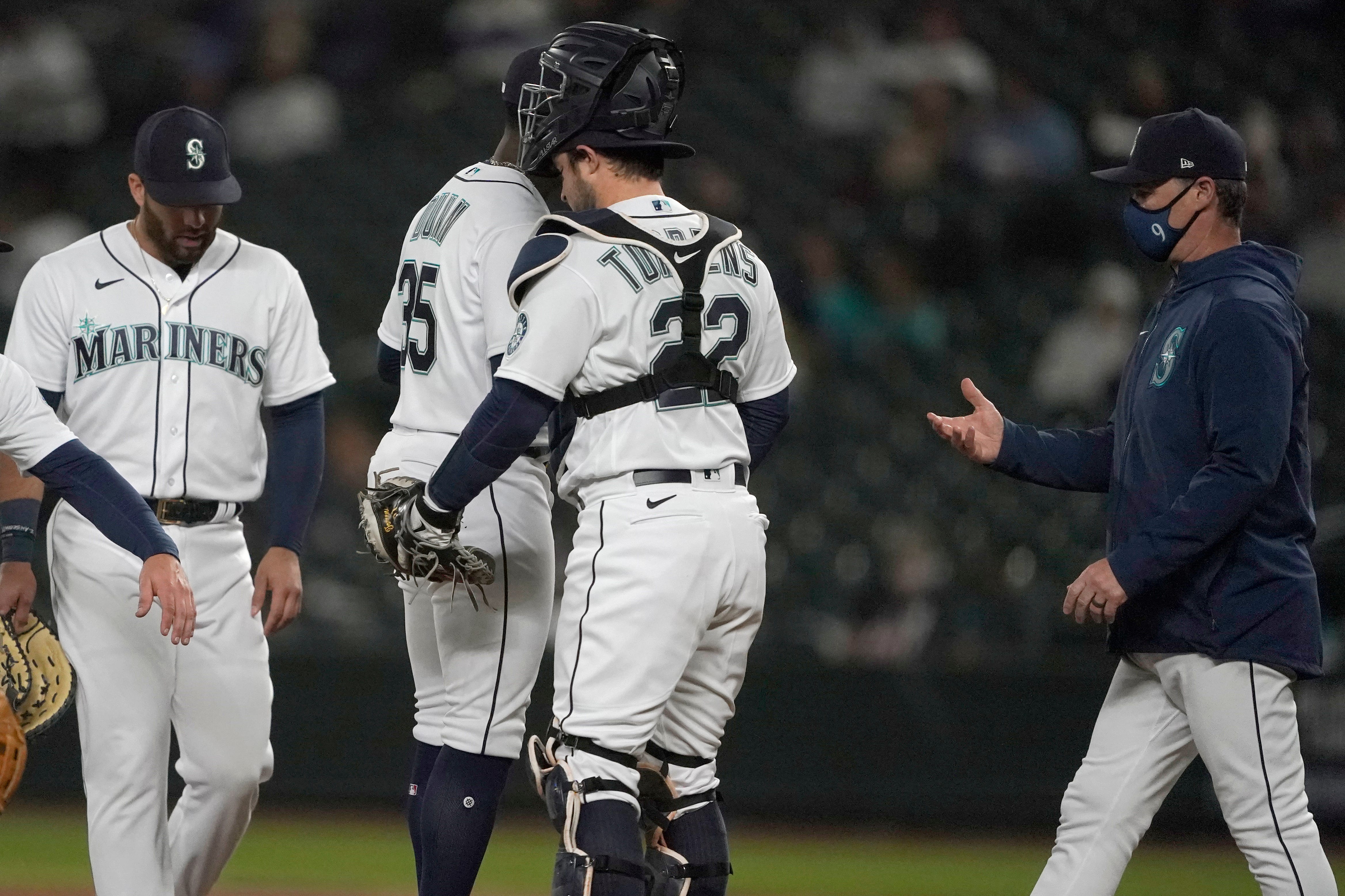 Seattle Mariners manager Scott Servais, right, pulls starting pitcher Justin Dunn, second from left, from the baseball game against the Detroit Tigers during the sixth inning.