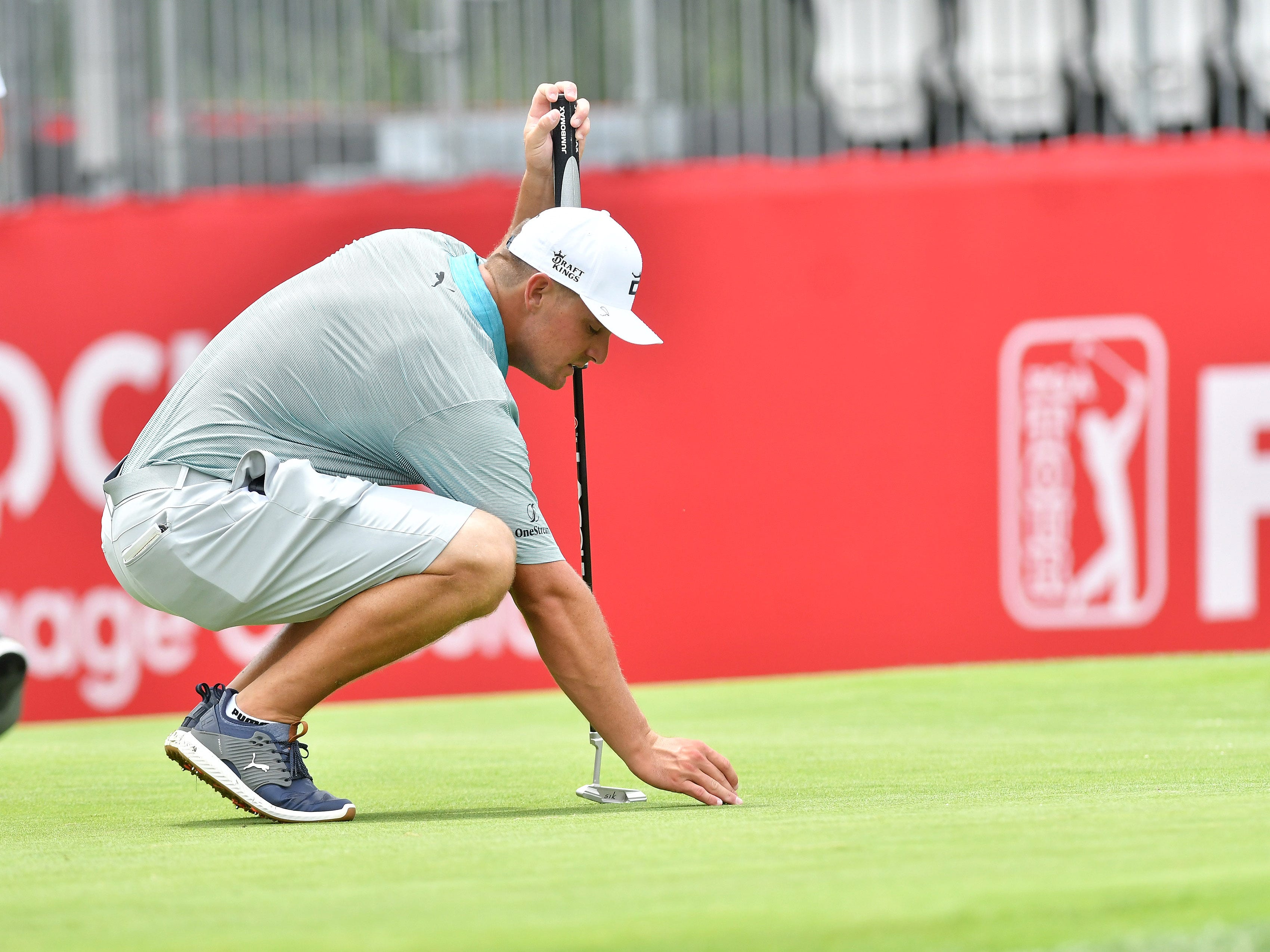 Bryson DeChambeau places his ball on the 15th green.
