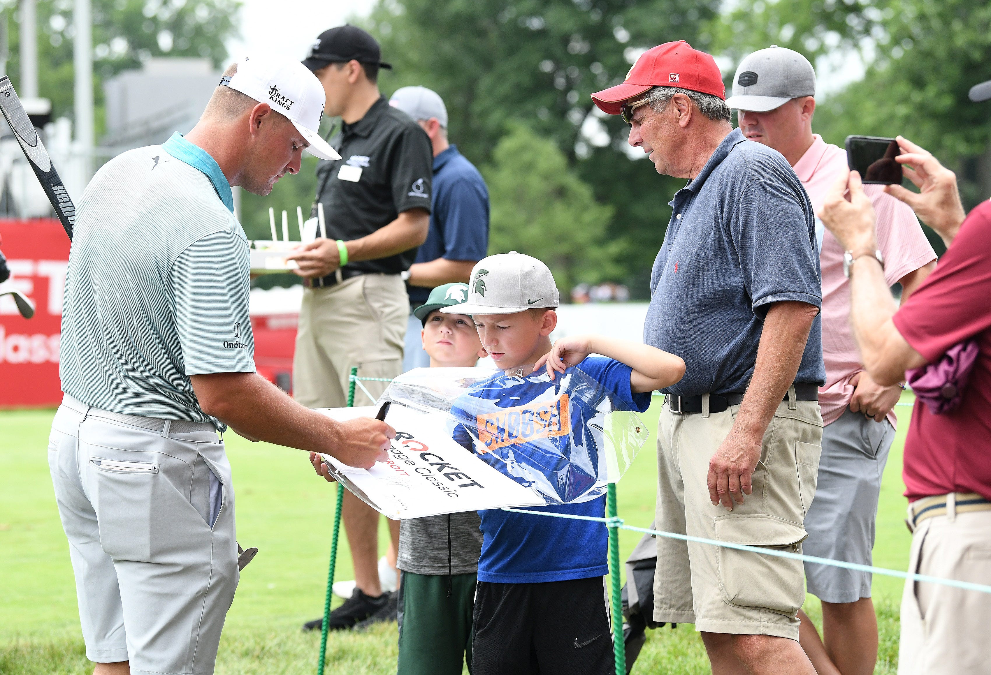 From left, Bryson DeChambeau stops to sign autographs for brothers Grady Goergen, 7, and Jacob Goergen, 10, with grandpa Don Goergen and dad Tim Goergen of Rochester at the 15th tee.
