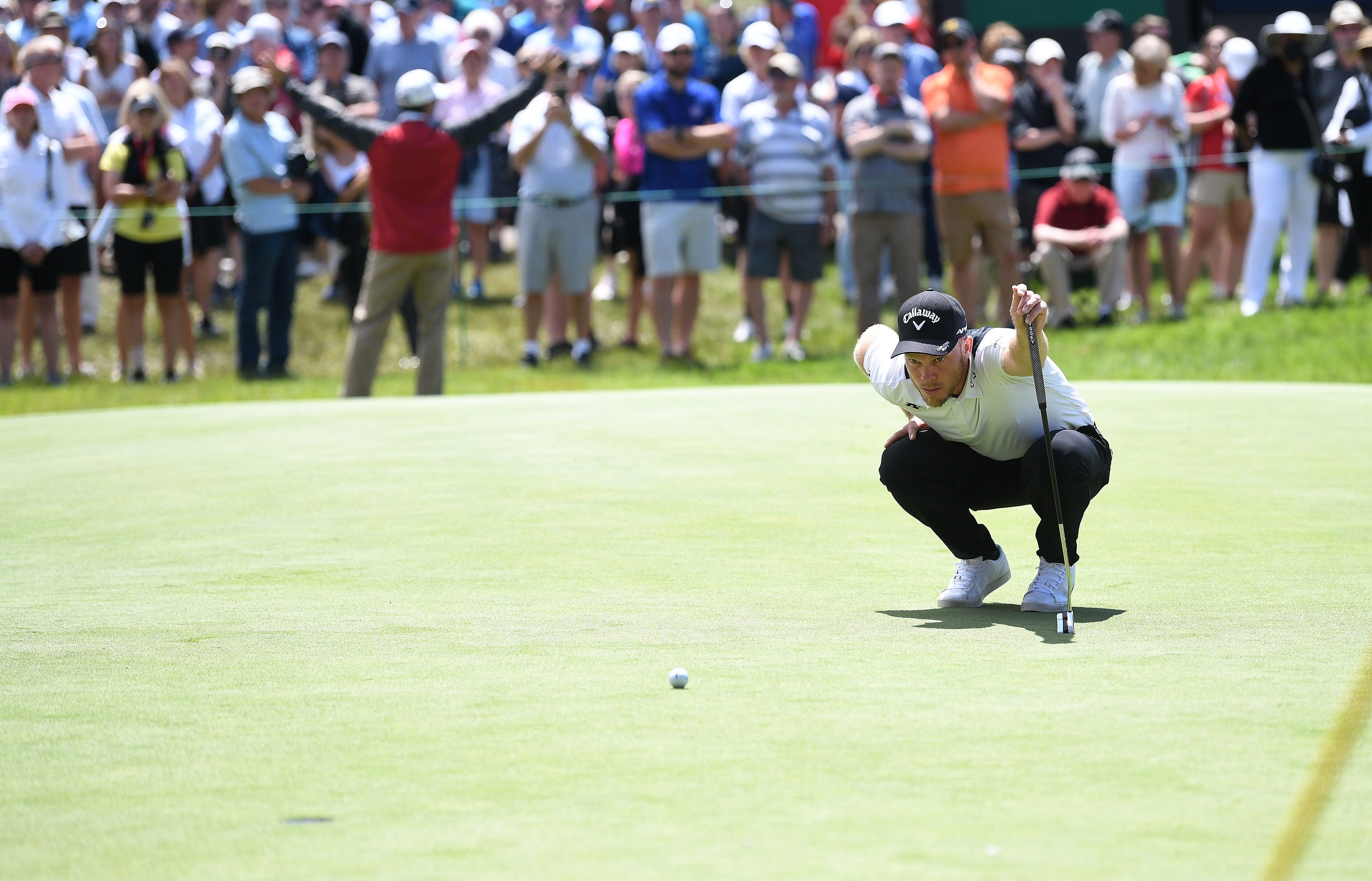 Danny Willett lines up his putt on the 18th green.