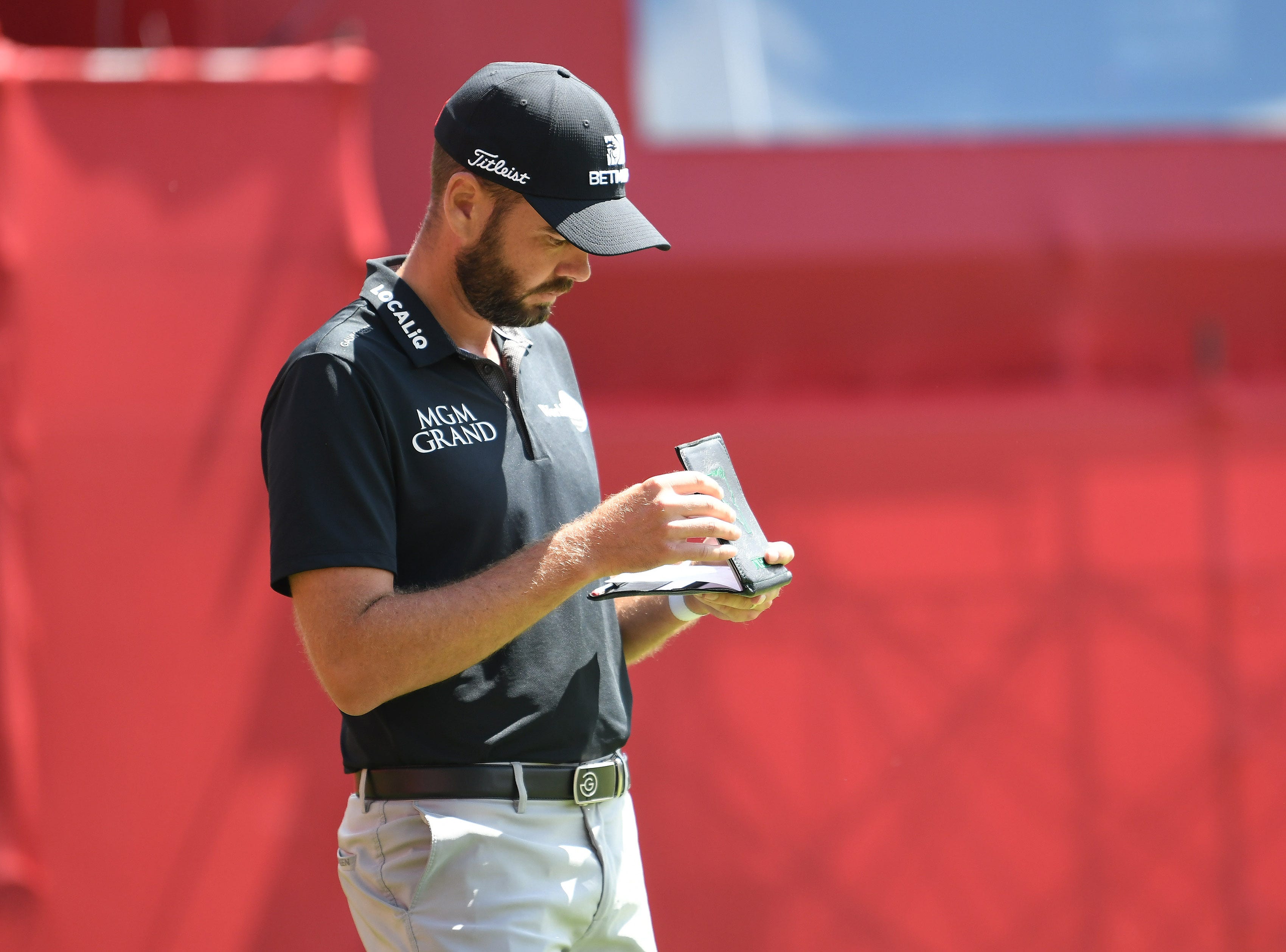 Troy Merritt looks over his notes on hole No. 18.