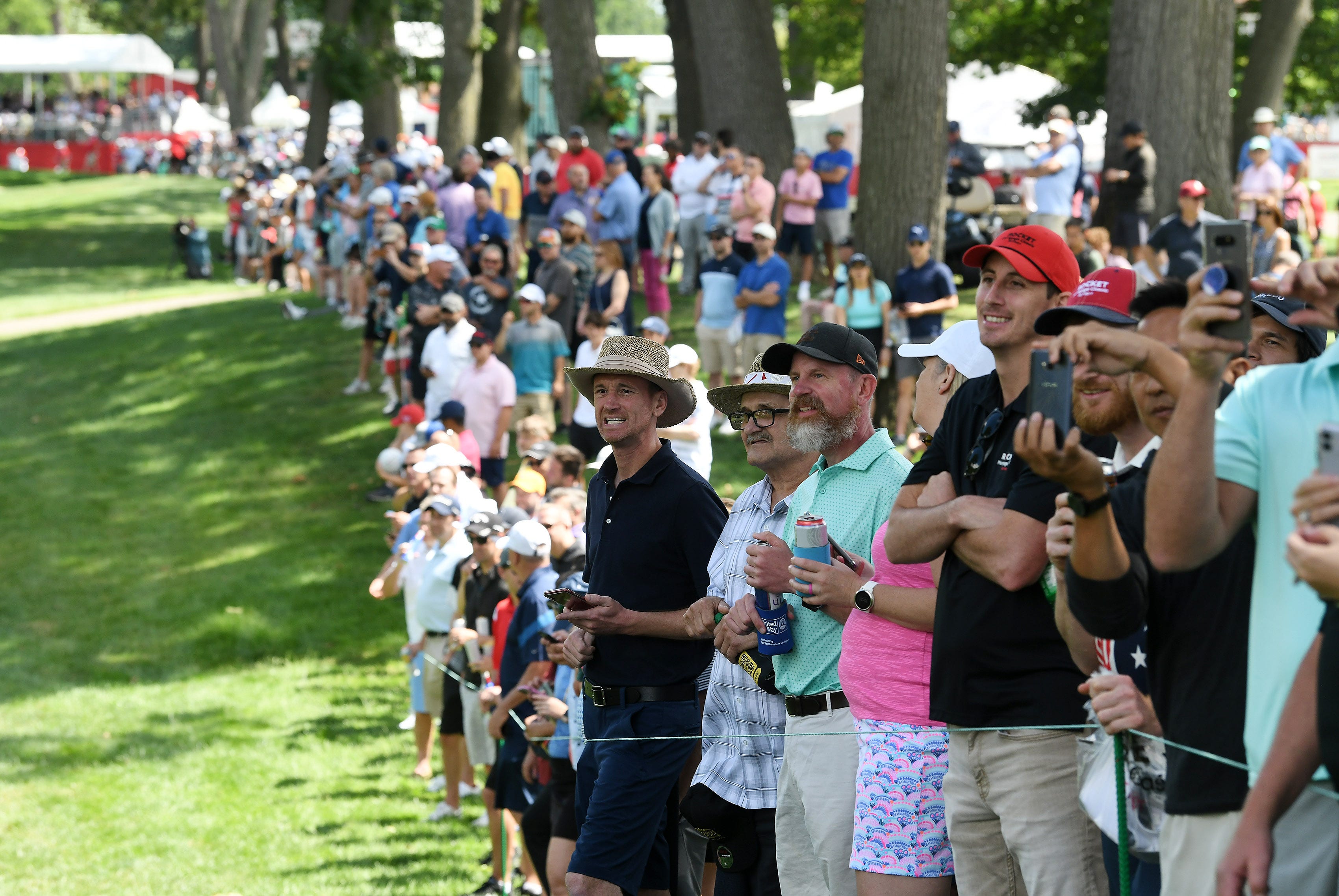 Fans watch and some cheer for Phil Mickelson as he walks up the ninth fairway.