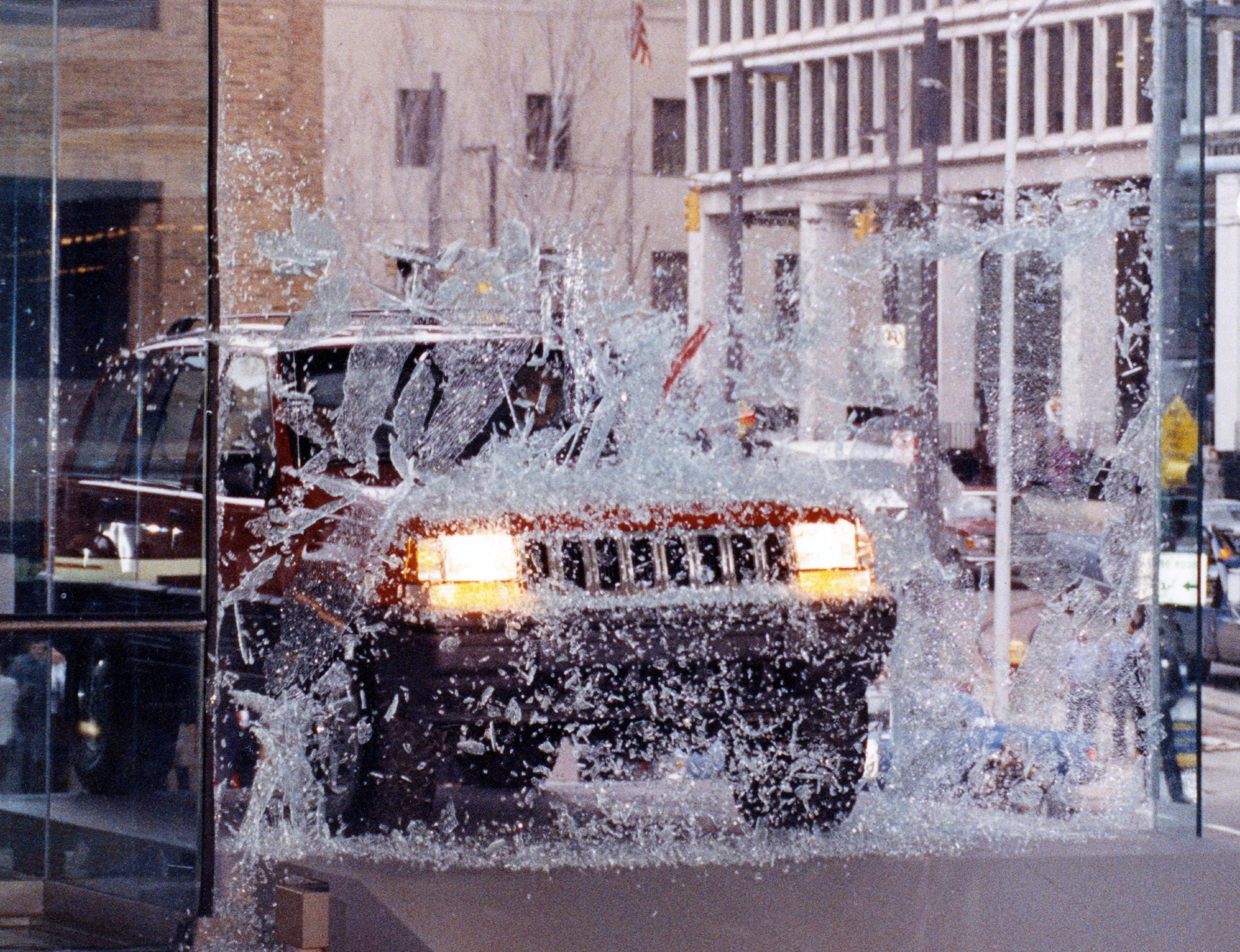 A 1993 Jeep Grand Cherokee driven by Chrysler's Bob Lutz with Detroit Mayor Coleman Young as a passenger smashes through a plate glass window and into Cobo Hall for its debut at the 1992 North American International Auto Show.