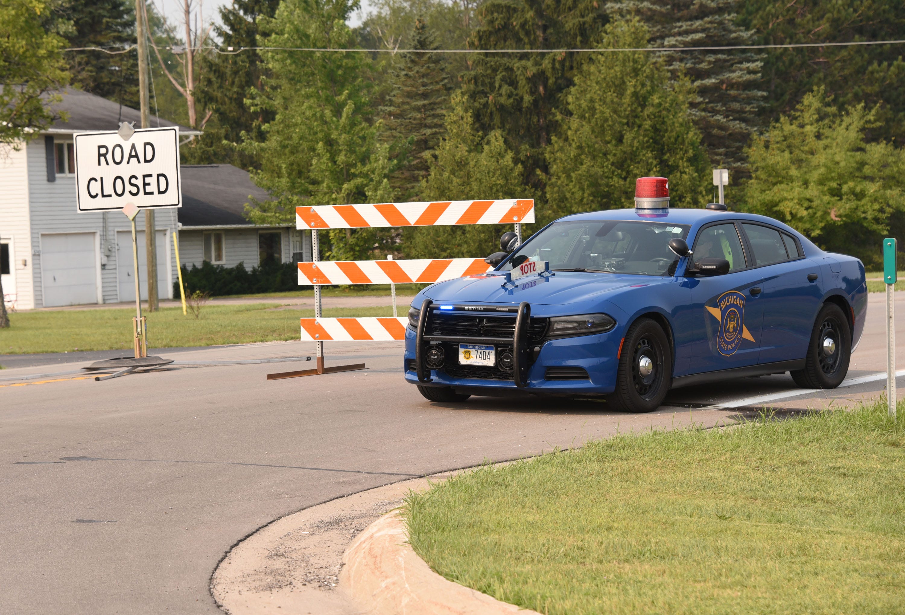 A Michigan State trooper sits at a side road west of Alpena Thursday, August 5, 2021 at the Air National Guard lands four aircraft on highway M-32, part of a training exercise. The highway was closed to traffic for hours.