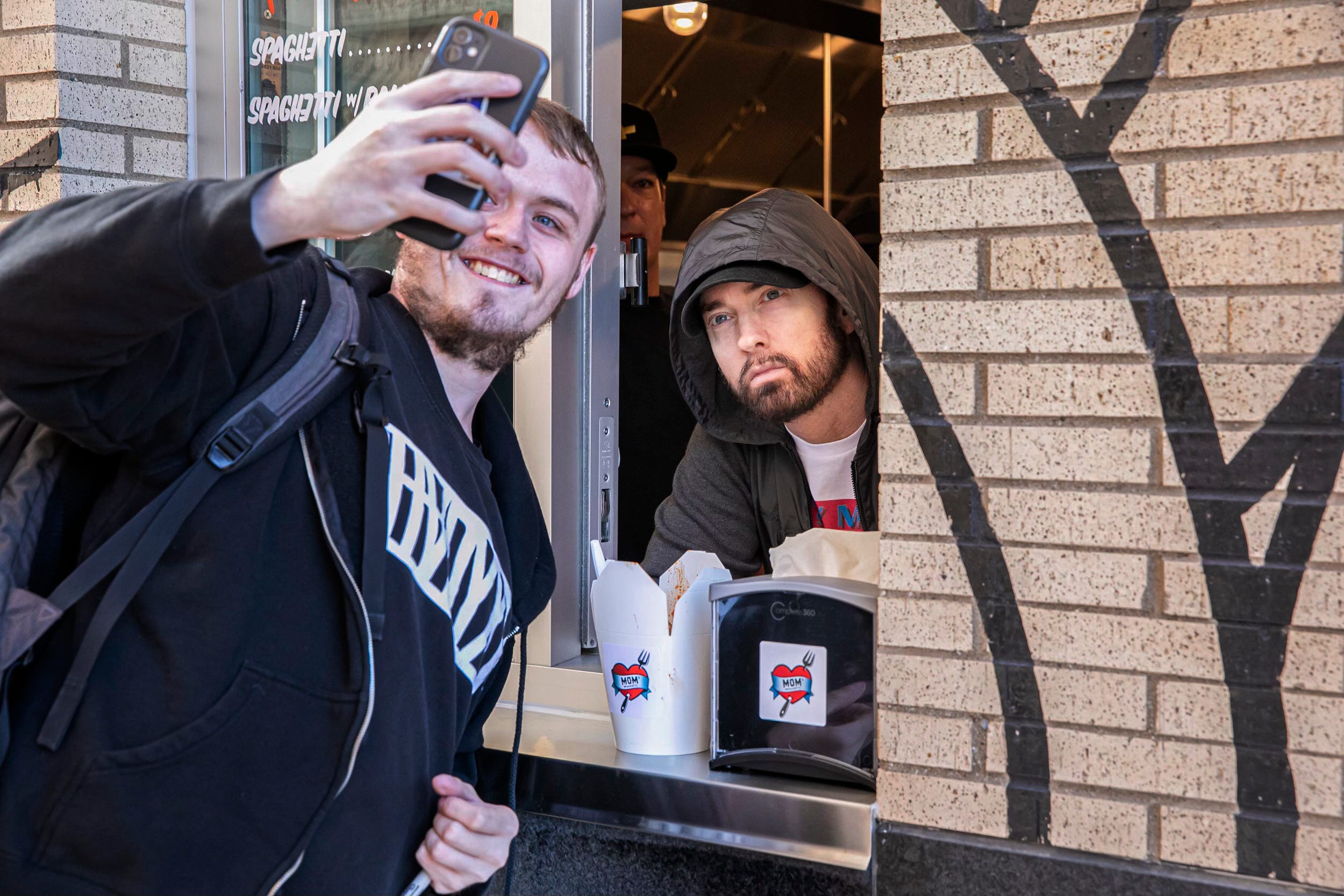 Fan Brendan Linden of the Bronx, New York, takes a selfie with Eminem after buying some Mom’s Spaghetti from the Detroit rapper at the walk-up window of his new restaurant in Detroit on Wednesday, Sept. 29, 2021.