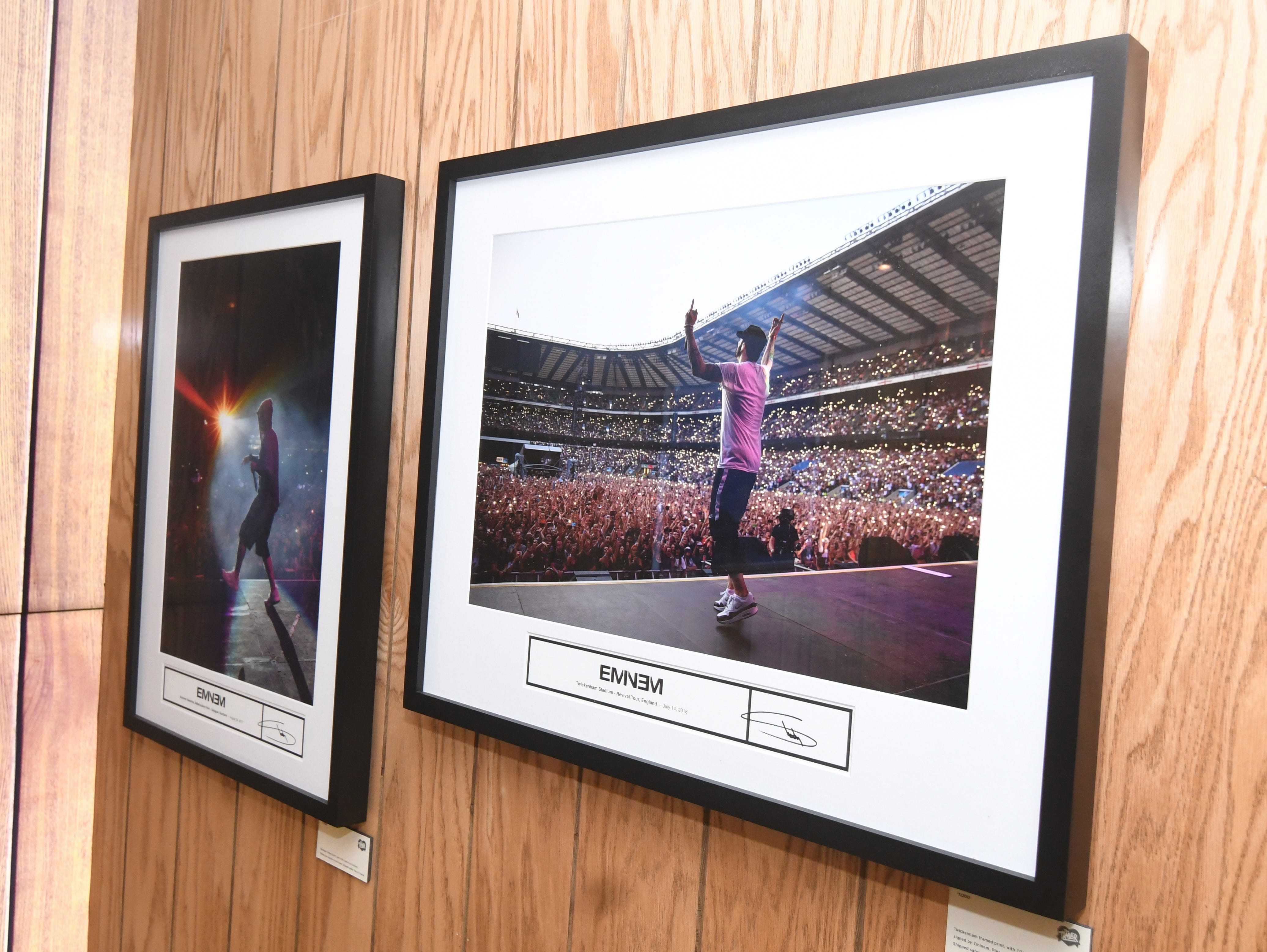 Framed signed photographs from Eminem's Revival Tour are for sale inside The Trailer retail shop at Mom's Spaghetti.
