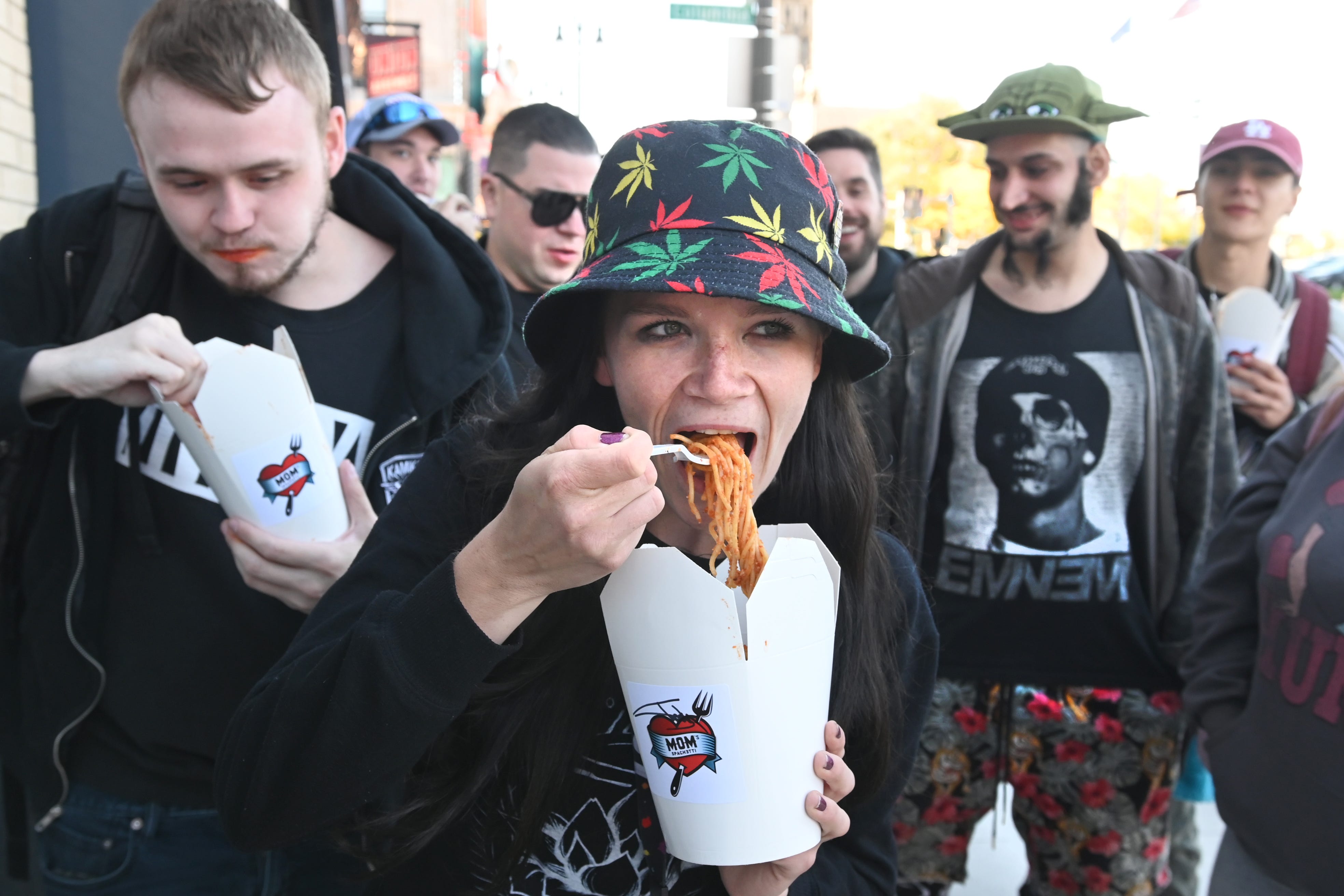 Erin Farrer, of Detroit, enjoys Mom’s Spaghetti as she waits outside rapper Eminem’s restaurant in downtown Detroit.