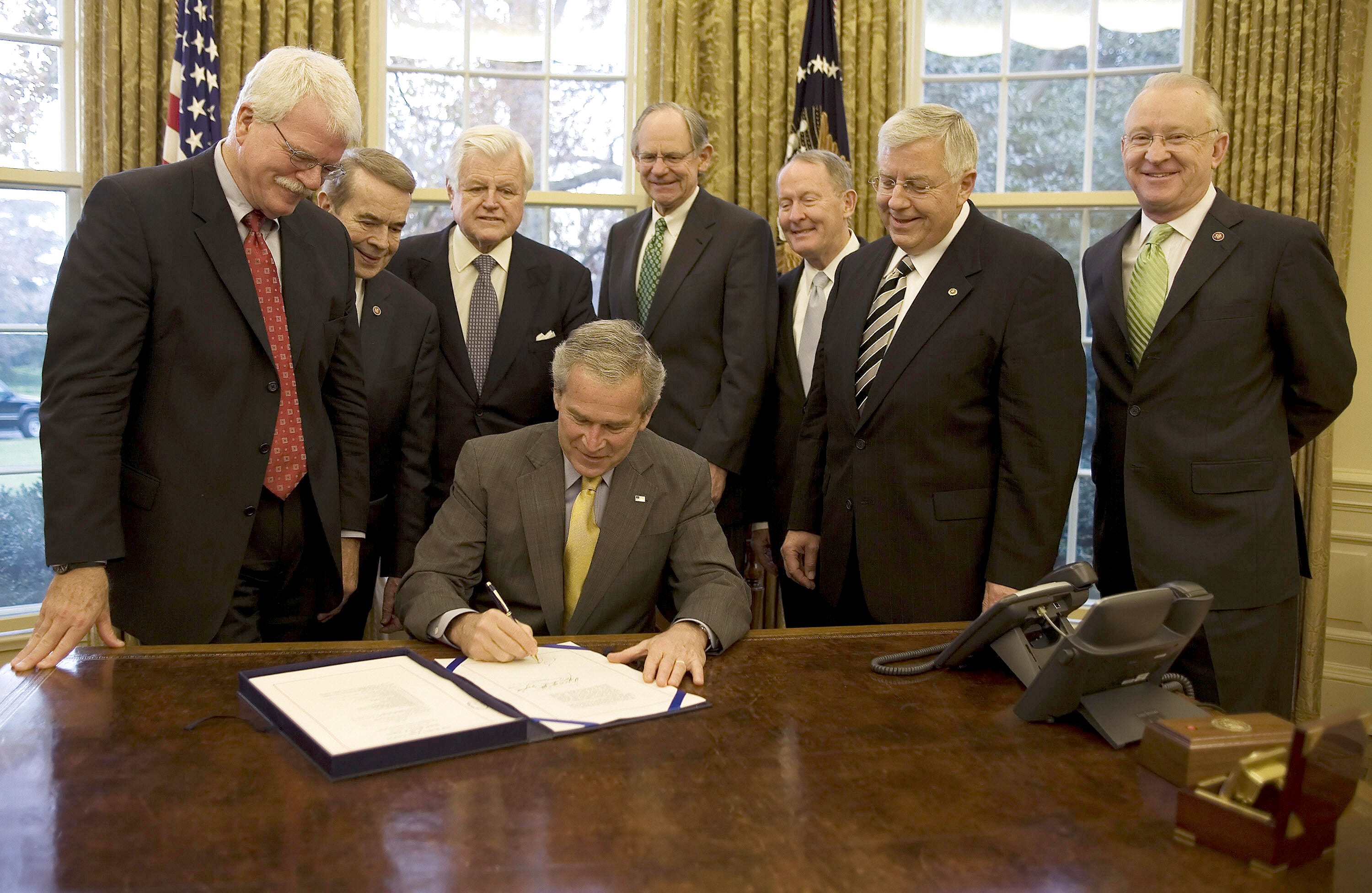 President George W. Bush (center) signs H.R. 1429, the Improving Head Start for School Readiness Act of 2007, with Congressman George Miller (left), D-Calif.; Congressman Dale Kildee (2nd from left), D-Michigan; U.S. Sen. Ted Kennedy (3rd from left), D-Mass.; Congressman Mike Castle (4th from left), R-Delaware; U.S. Sen. Lamar Alexander (3rd from right), R-Tenn.; U.S. Sen. Mike Enzi (2nd from right), R-Wyoming; and Congressman Buck McKeon (right), R-Calif., in the Oval Office of the White House in Washington, D.C., on Dec. 12, 2007.