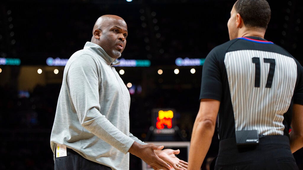 Hawks head coach Nate McMillan, left, talks with a referee during the second half of Monday's game against the Pistons in Atlanta.