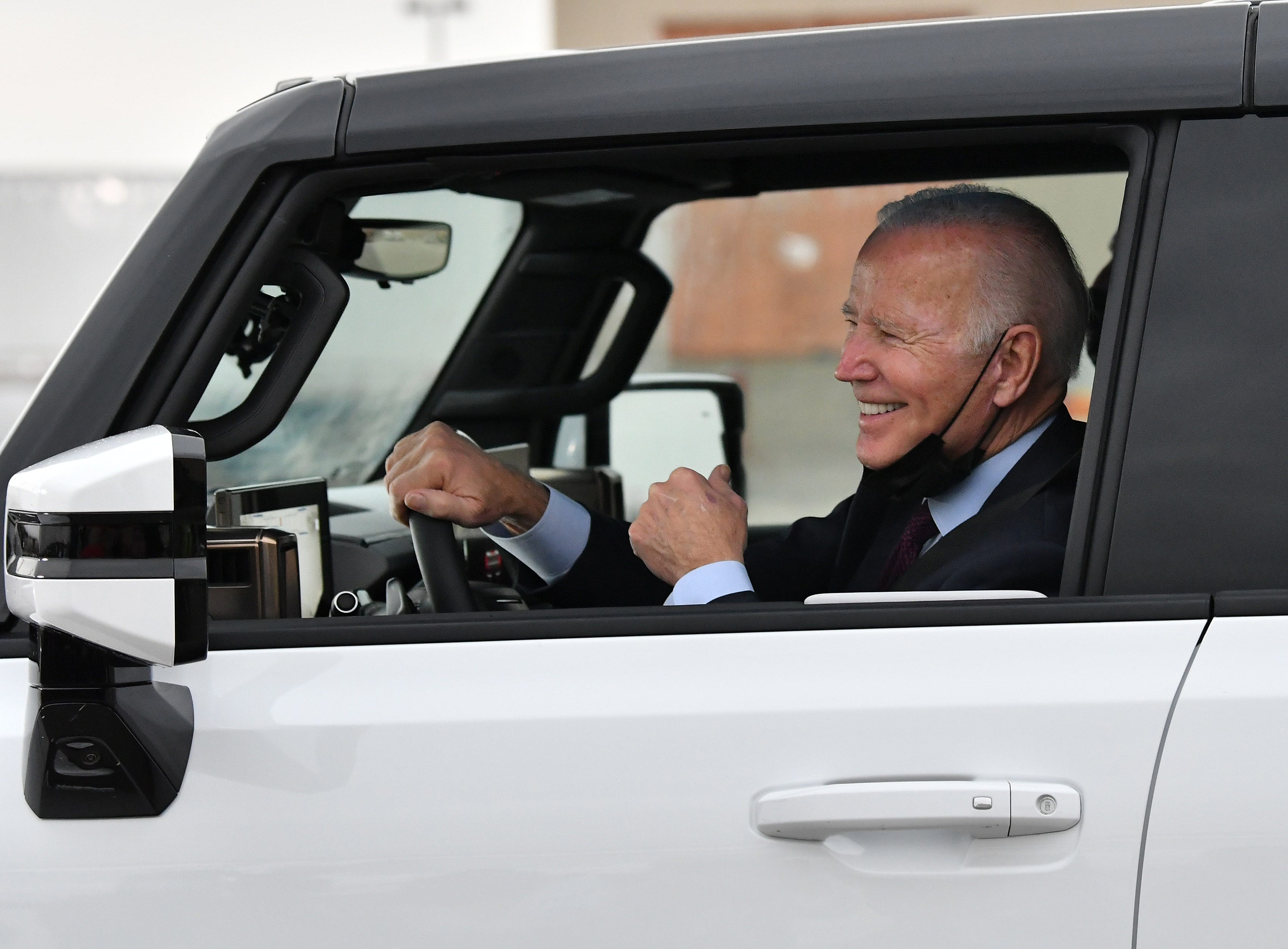 President Joe Biden smiles after driving the GMC Hummer EV PIckup at the General Motors' Factory ZERO electric vehicle assembly plant, in Detroit, November 17, 2021.