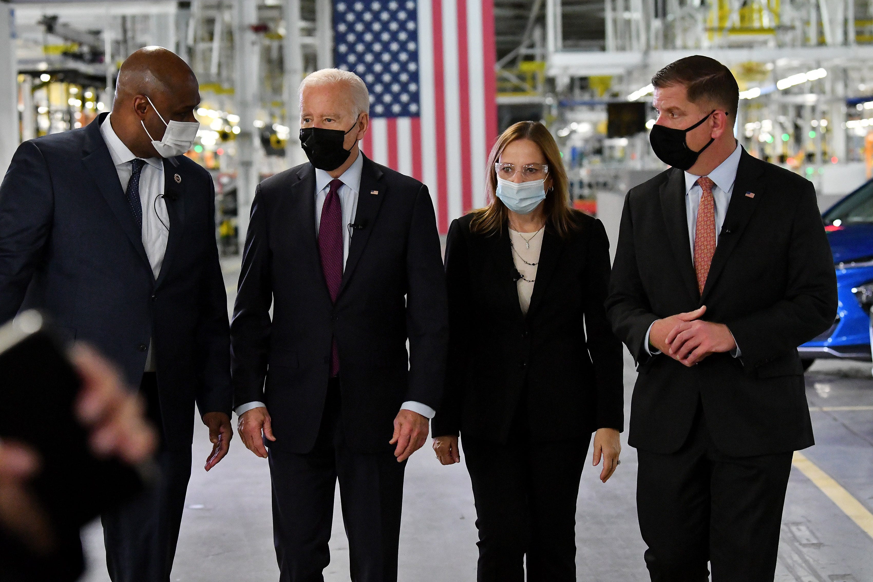 From left, UAW President Ray Curry, President Joe Biden, General Motors CEO Mary Barra and U.S.Labor Secretary Marty Walsh walk through General Motors' Factory ZERO electric vehicle assembly plant, in Detroit, November 17, 2021.
