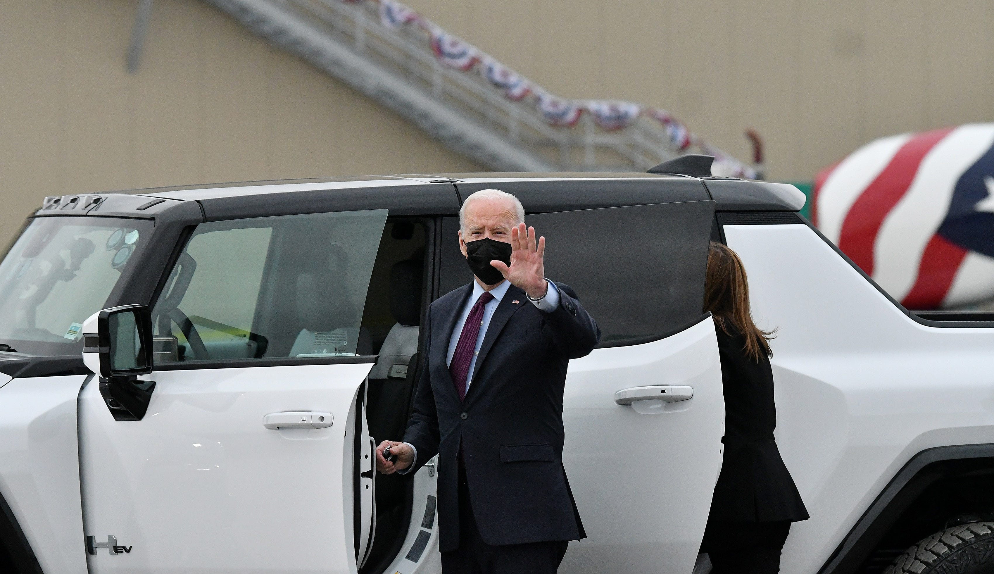 President Joe Biden waves before he drives the GMC Hummer EV PIckup at the General Motors' Factory ZERO electric vehicle assembly plant, in Detroit, November 17, 2021.