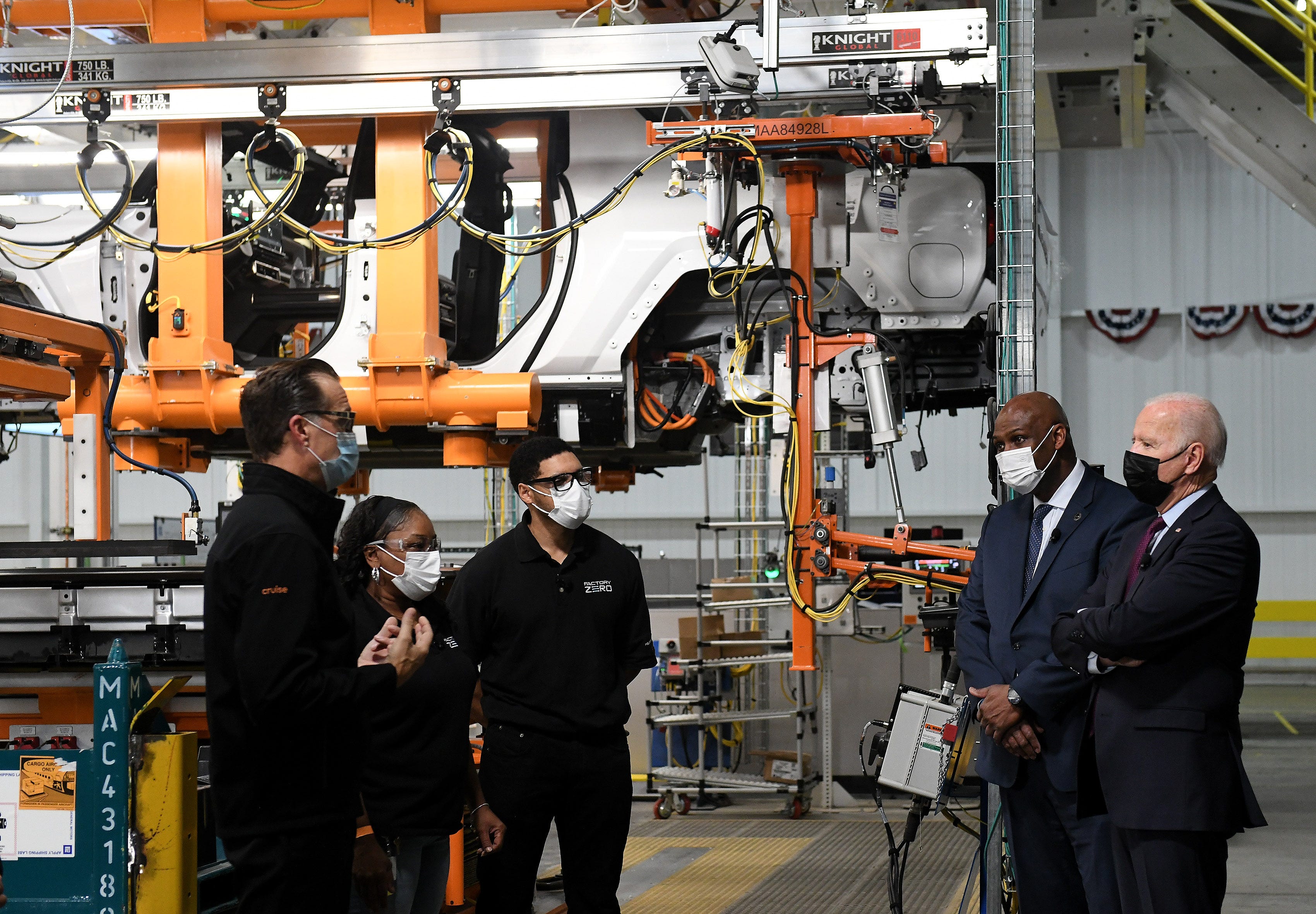 President Joe Biden, right, with UAW President Ray Curry looks at one of the battery areas with plant director Jim Quick, far left, at the General Motors Factory ZERO.